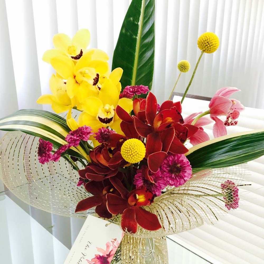 A vase filled with flowers and a card that says tea party