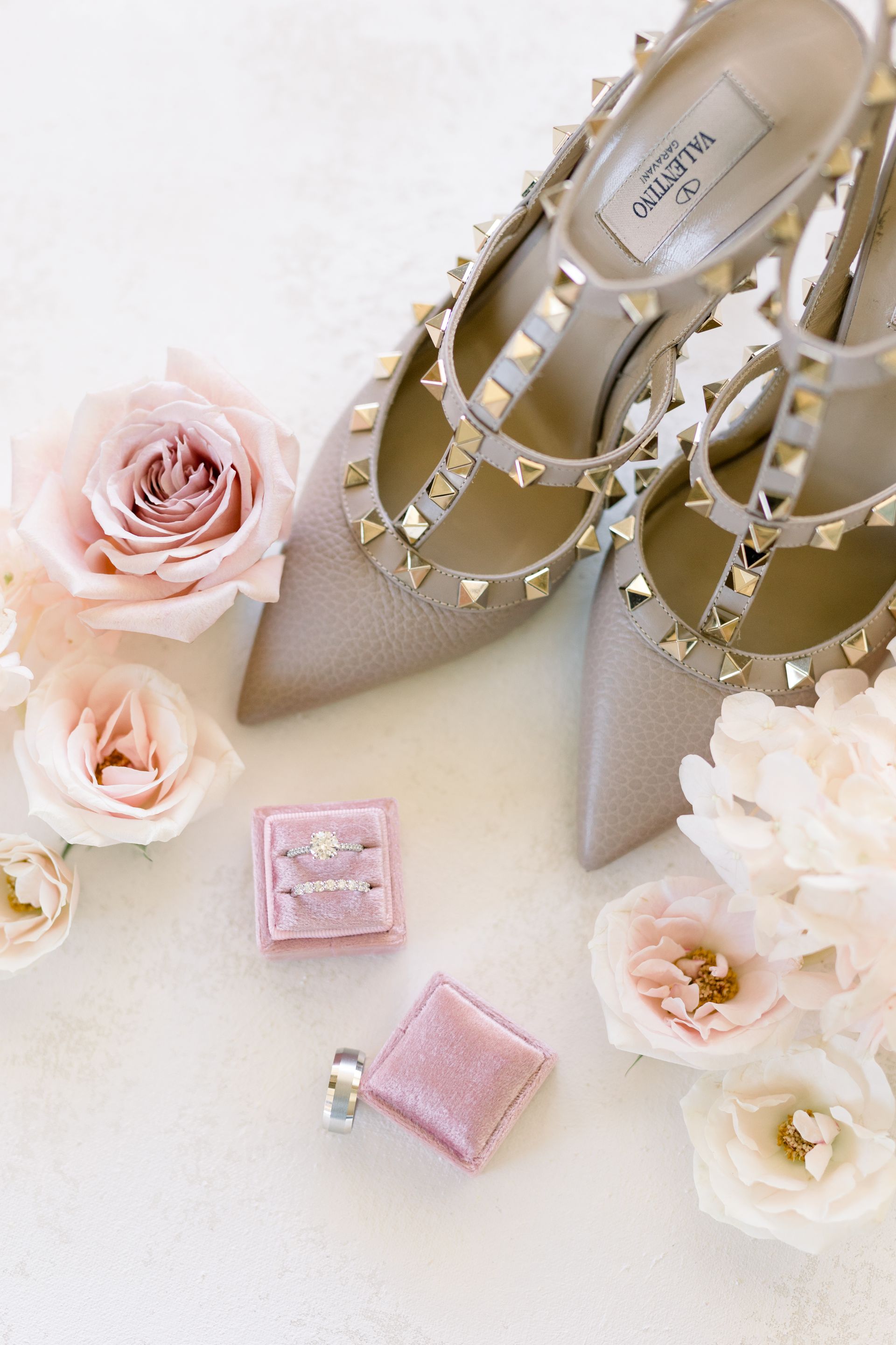 Elegant bridal flats, pink roses, and pink jewelry on a soft white background