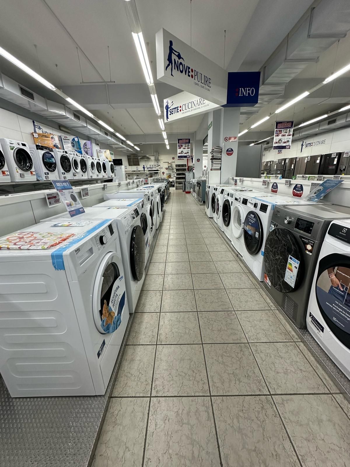 Una fila di lavatrici sono allineate in un negozio.