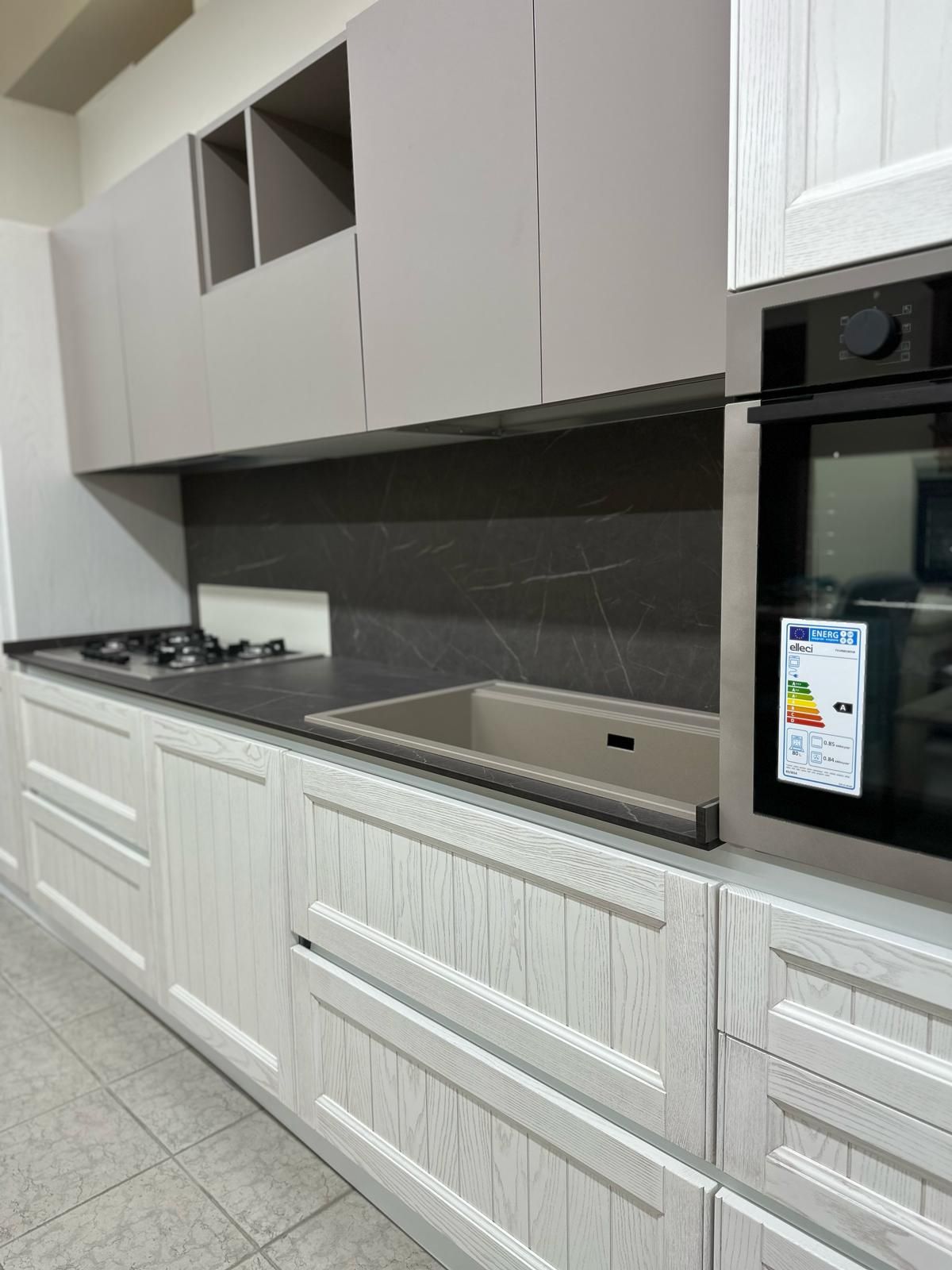 Una cucina con mobili bianchi e un piano cottura con forno