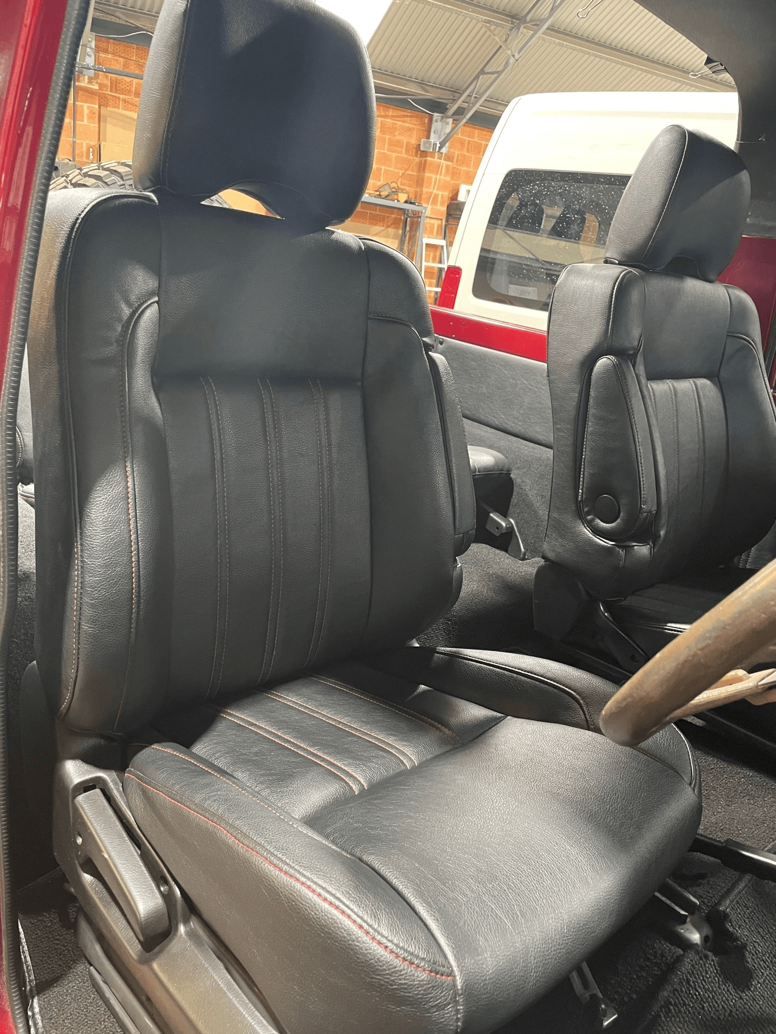 A Car With The Door Open With All Black Car Seats — Simmons Glass & Trim In Bathurst, NSW