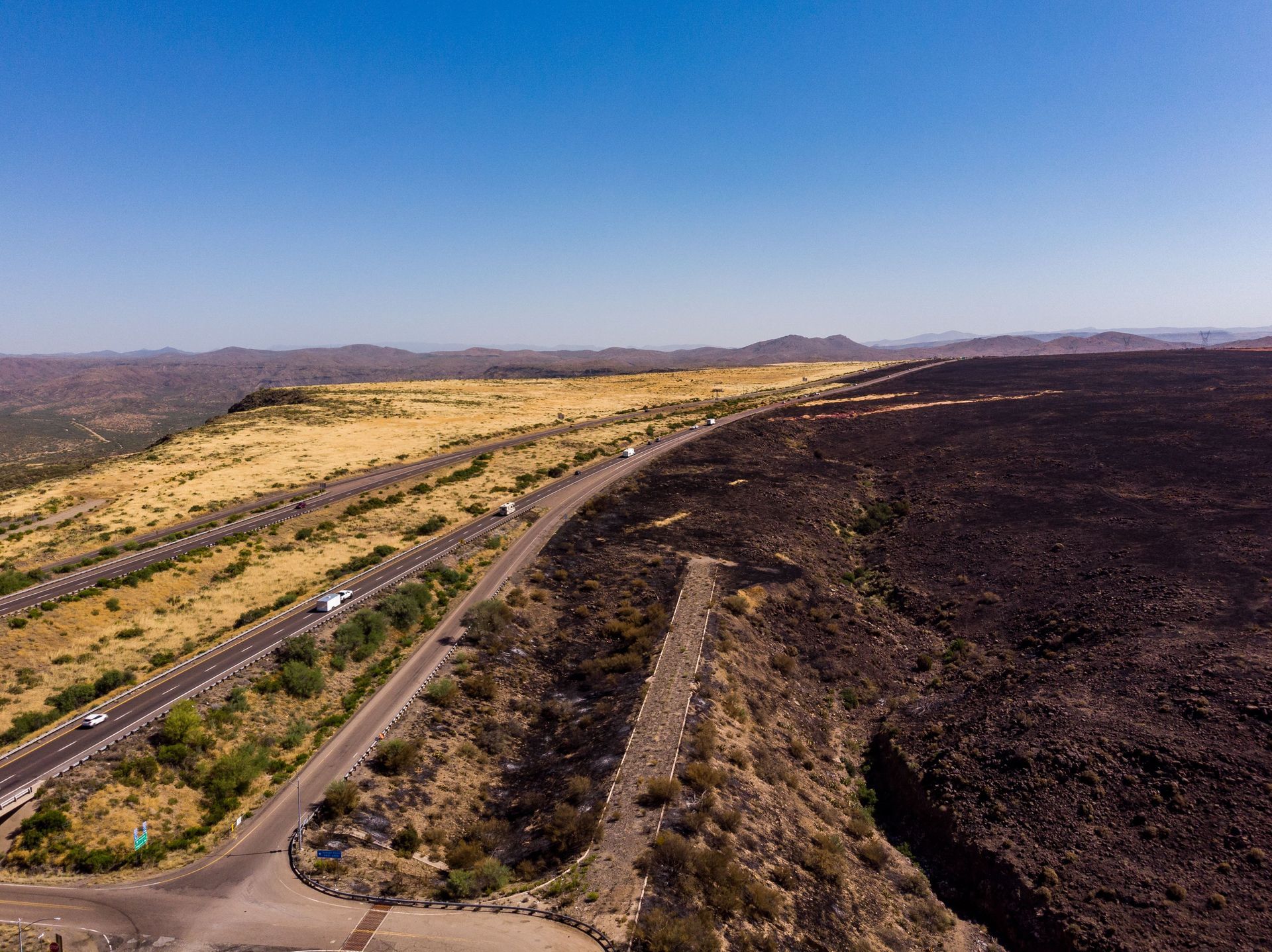 Desert highway with cars near Tucson, Arizona, the kind of road car insurance in Tucson covers