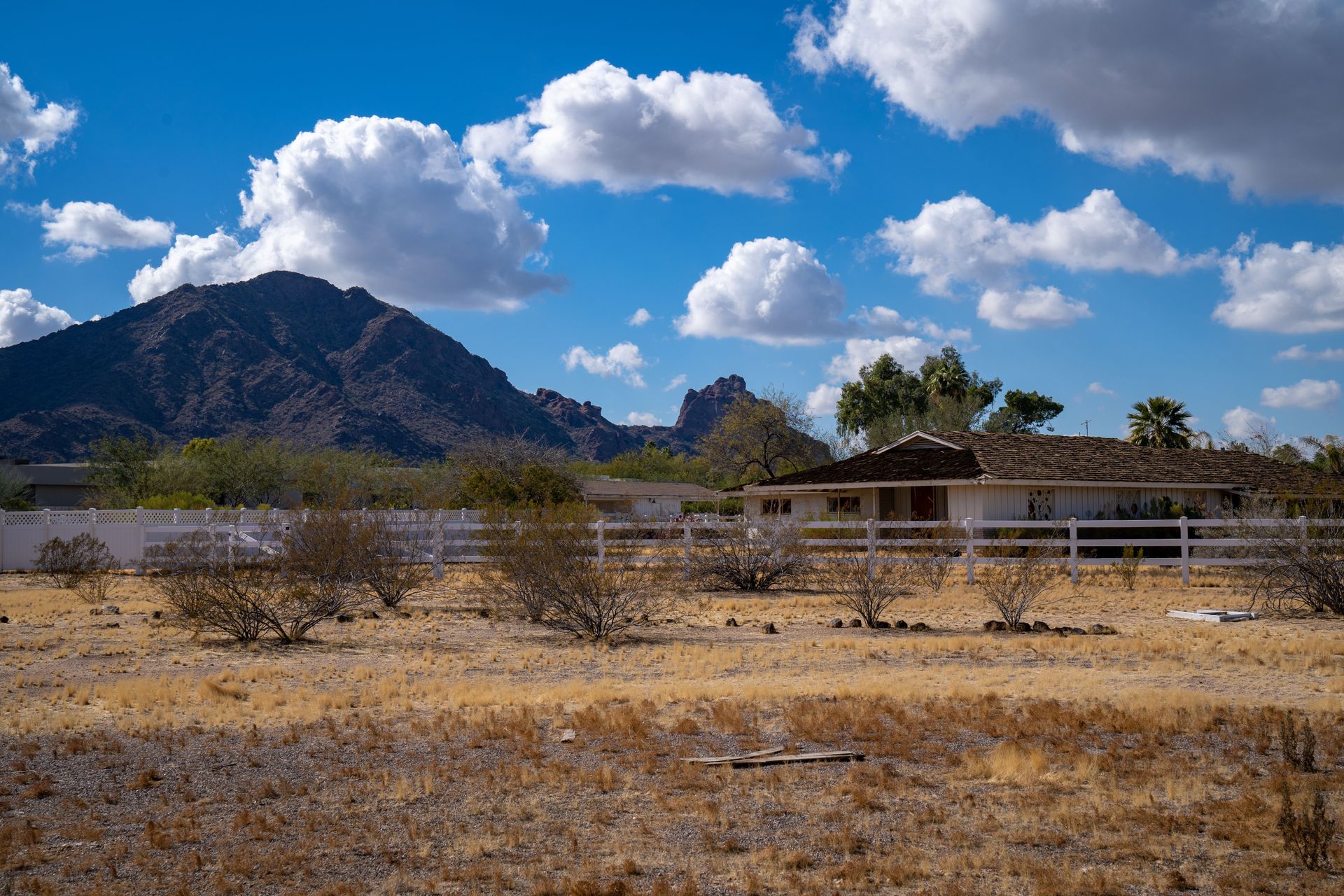 Arizona desert home surrounded by dry brush, showing fire peril risk for Arizona homeowners