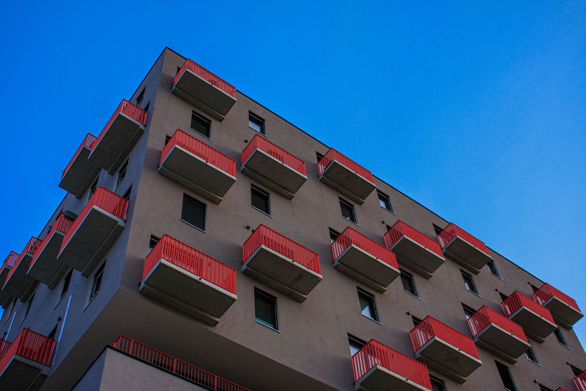 Modern apartment building with balconies under a blue sky, like many Arizona renters call home