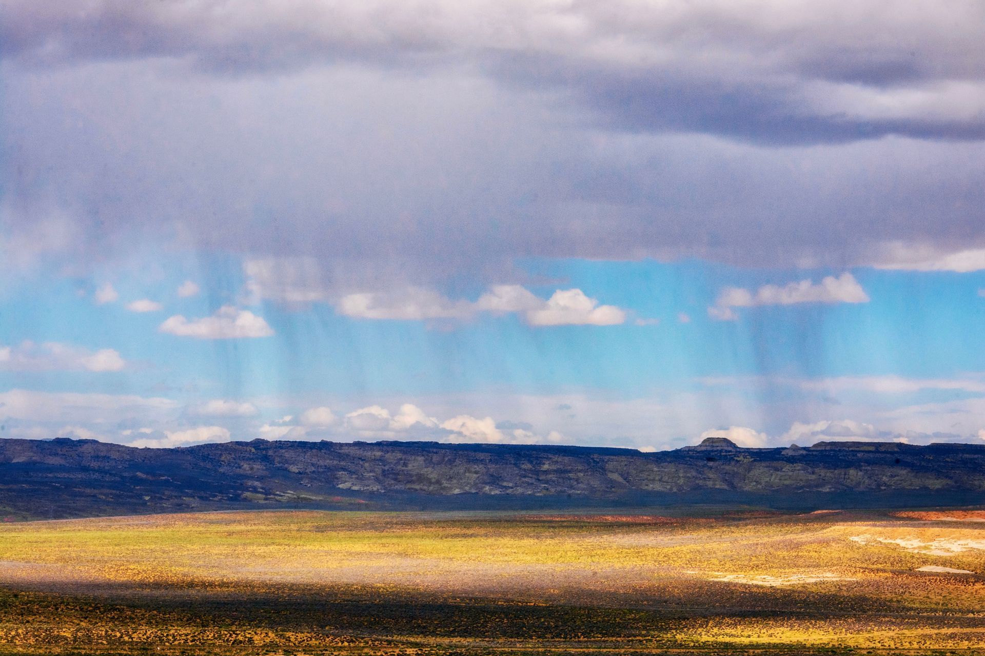 Monsoon storm clouds and desert rain moving over an Arizona valley as summer storms build
