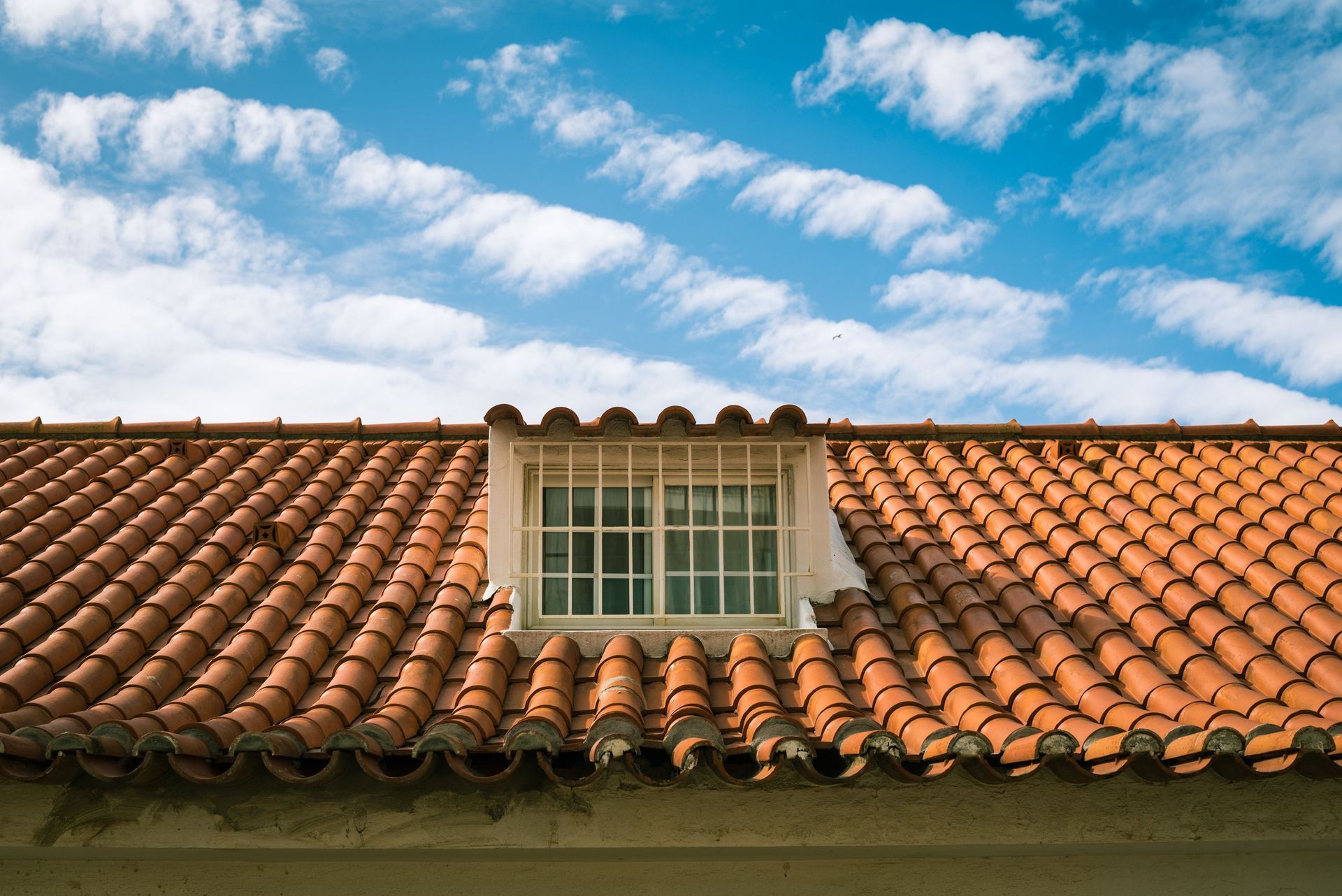 Terracotta tile roof on a home under clear blue sky, the roof type most exposed to Mesa Arizona monsoon wind and hail