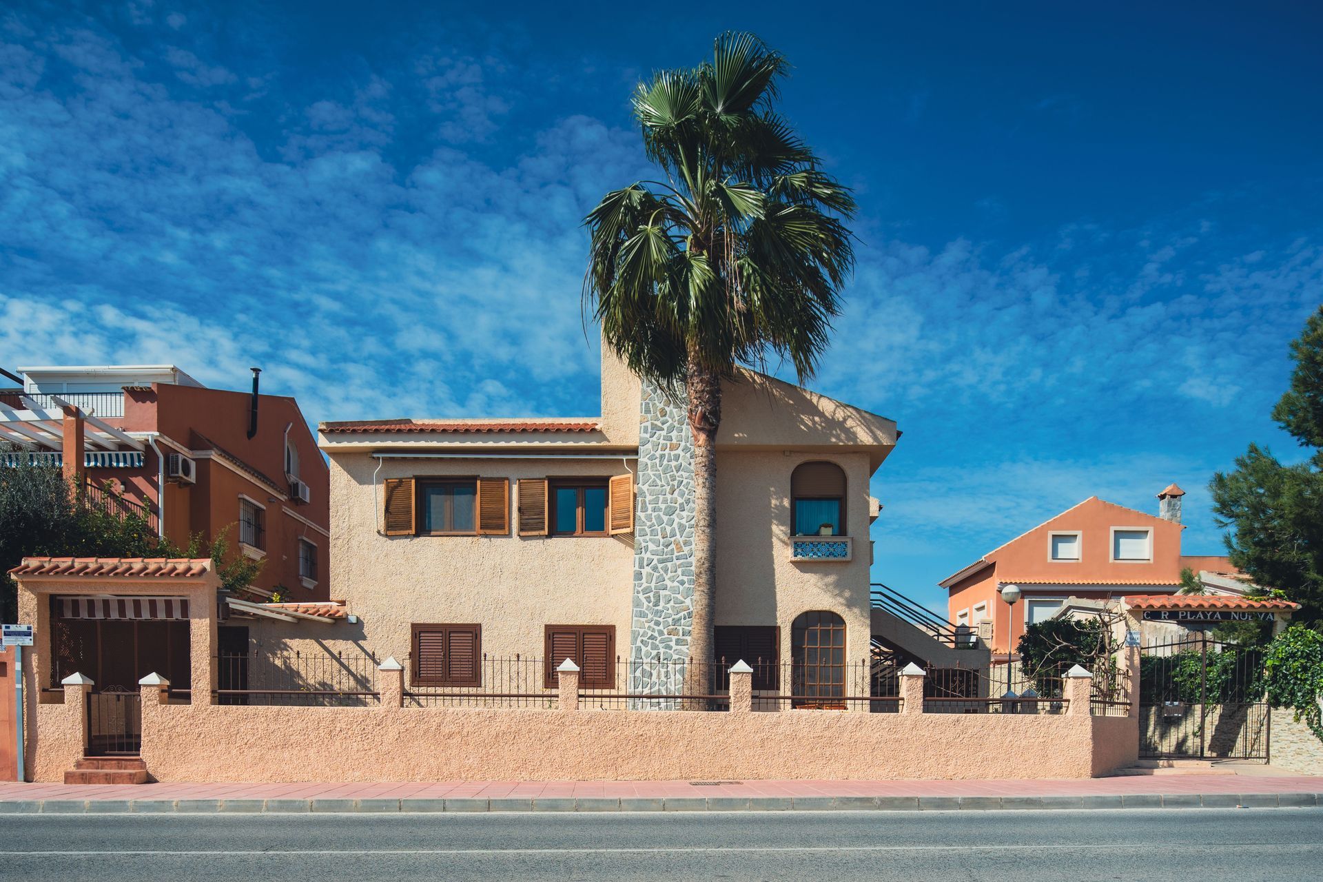 Terracotta stucco Arizona home with palm trees under blue sky, Progressive home insurance guide