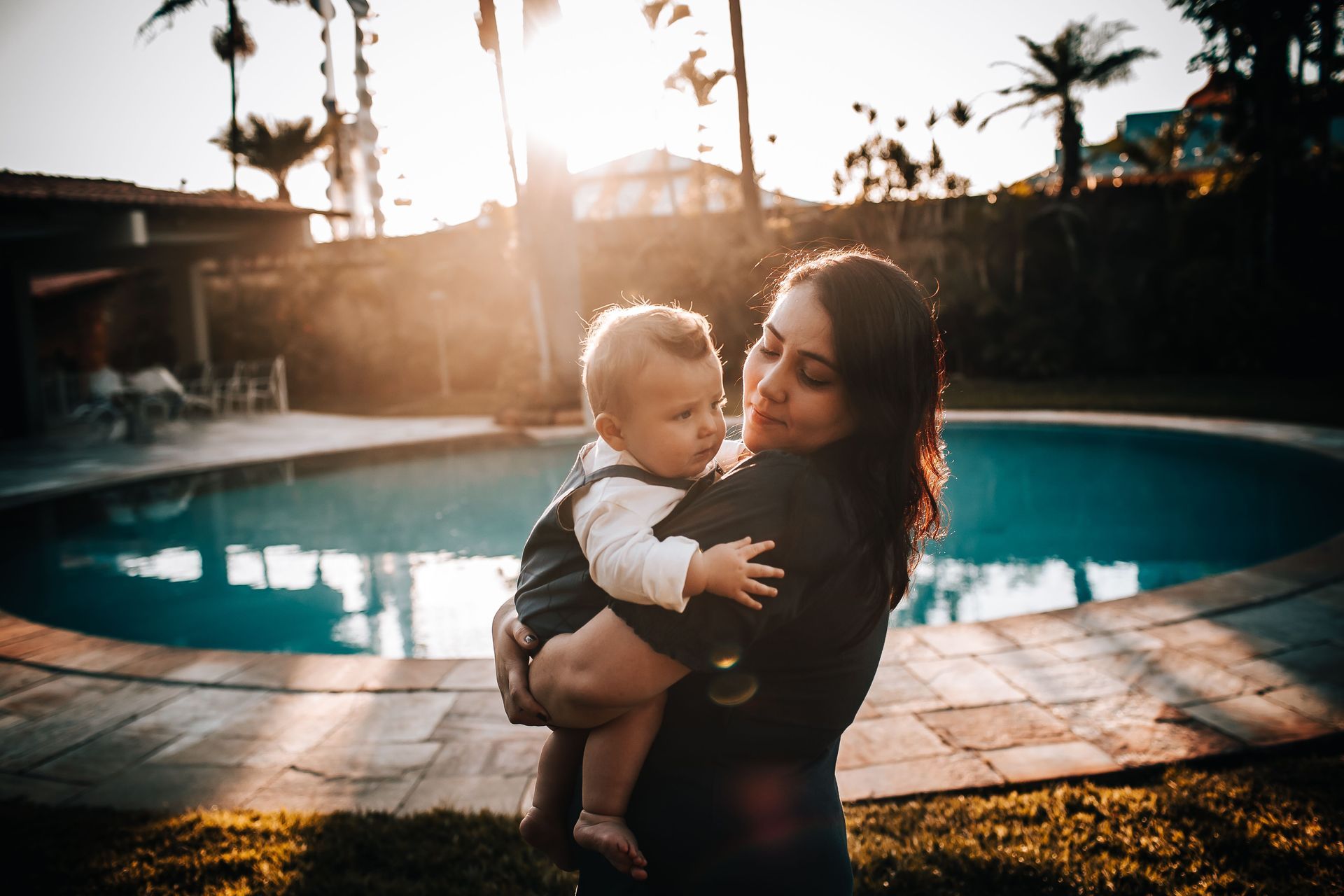 Parent holding a child beside a backyard swimming pool in Arizona, a common umbrella insurance risk