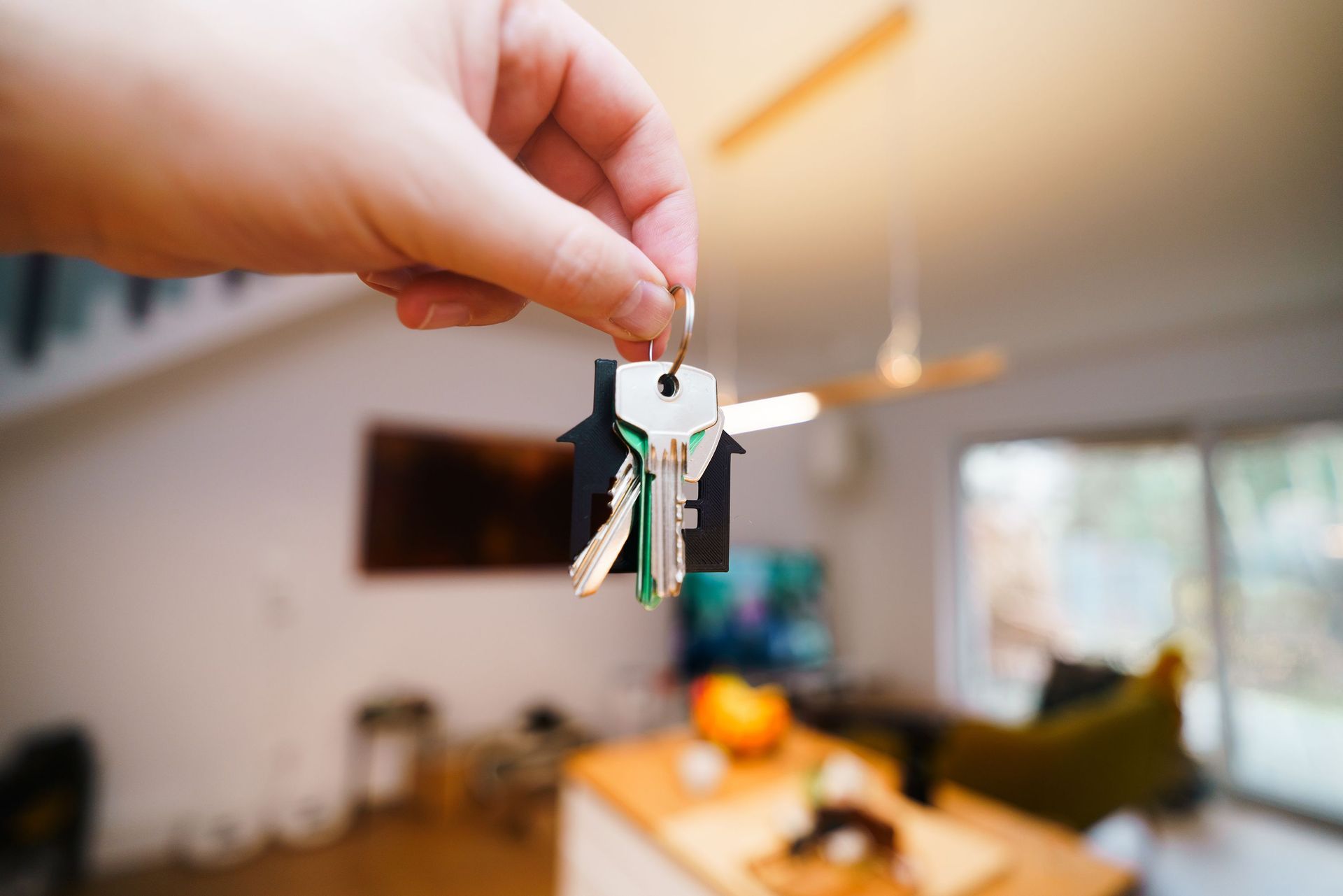 Host handing over house keys inside a bright Arizona short-term rental living room ready for guests