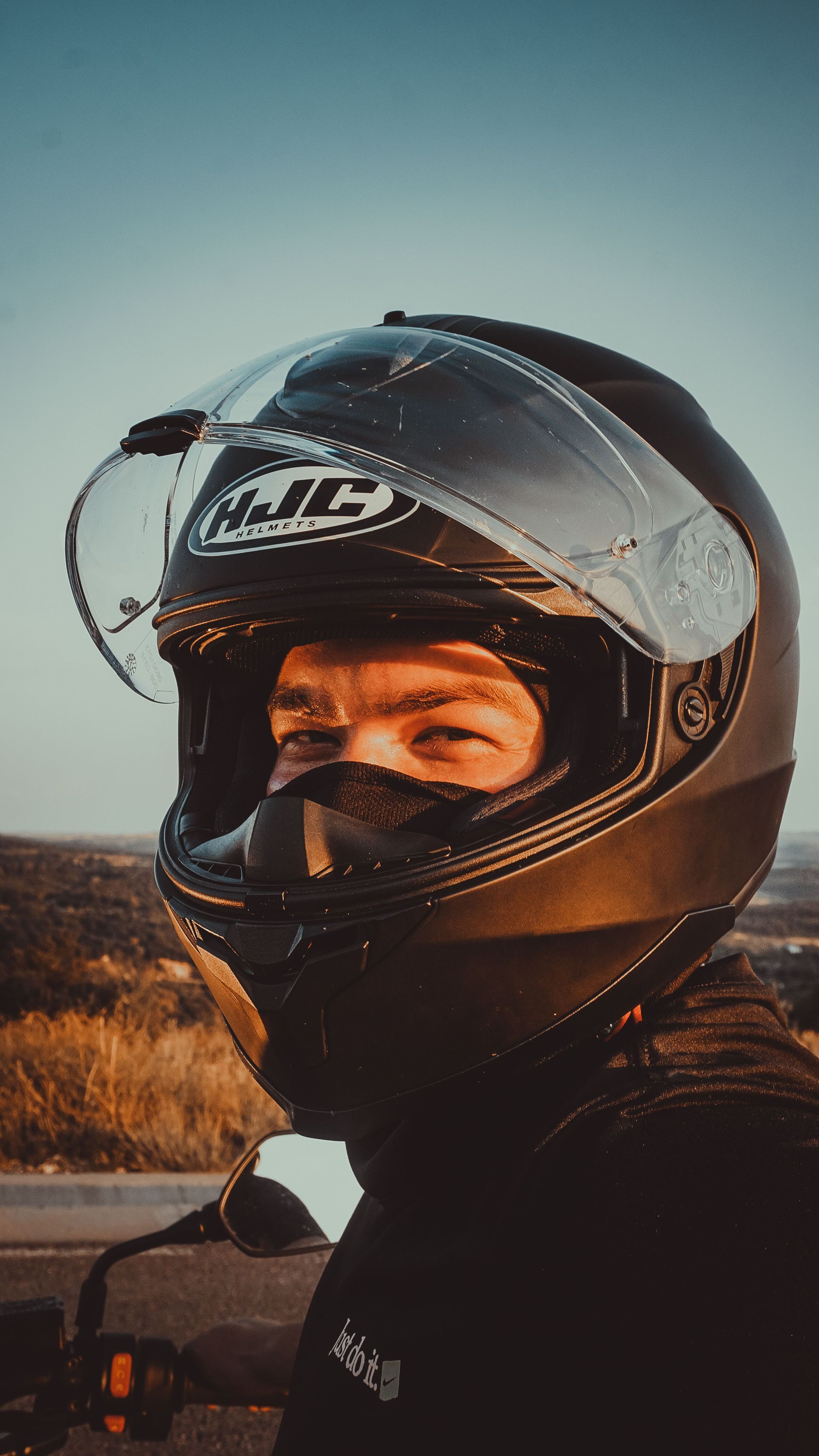 Motorcycle rider wearing a helmet, a reminder to review Arizona motorcycle insurance