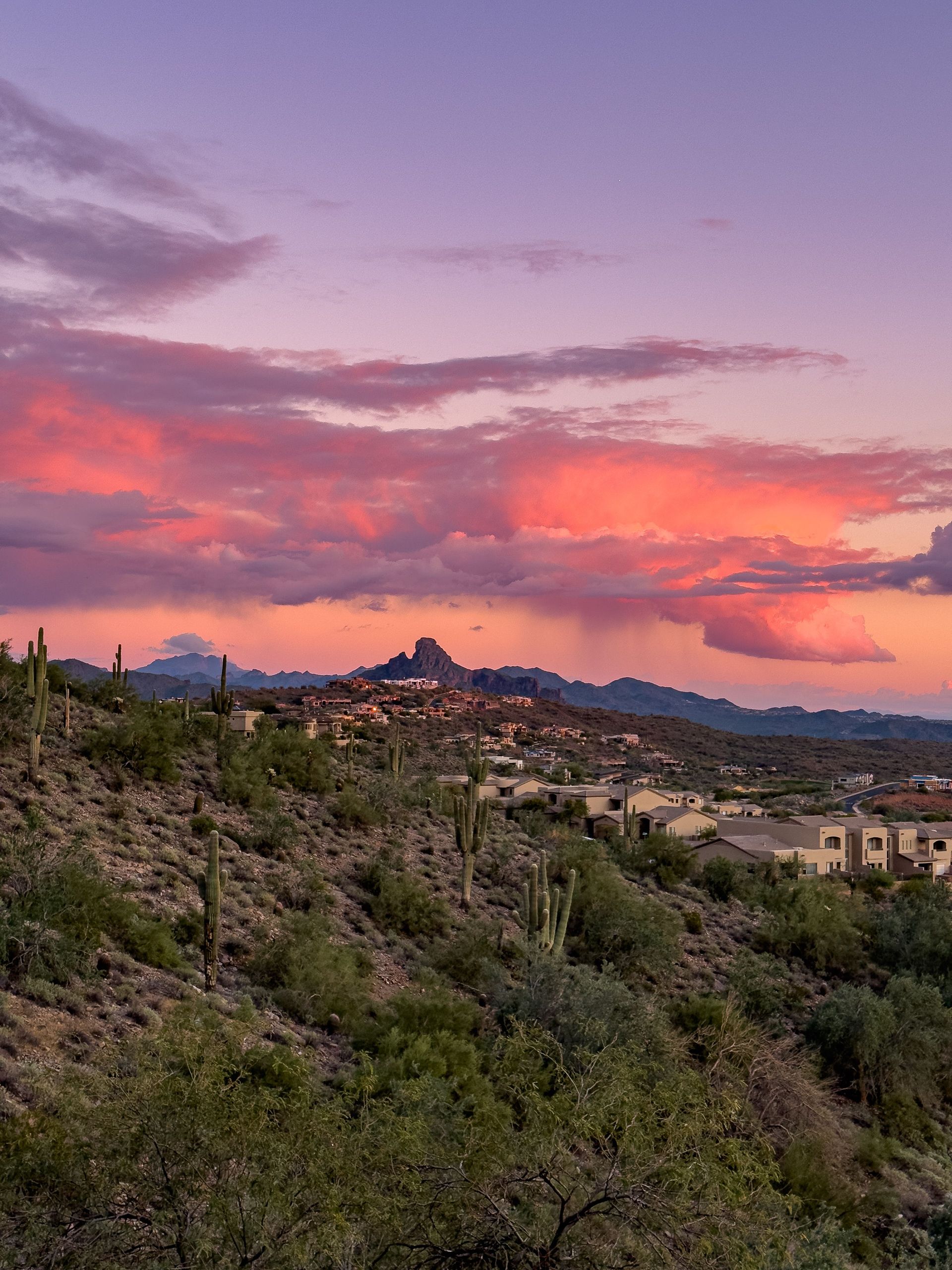 Monsoon storm clouds at sunset over Arizona desert homes near Glendale in the West Valley
