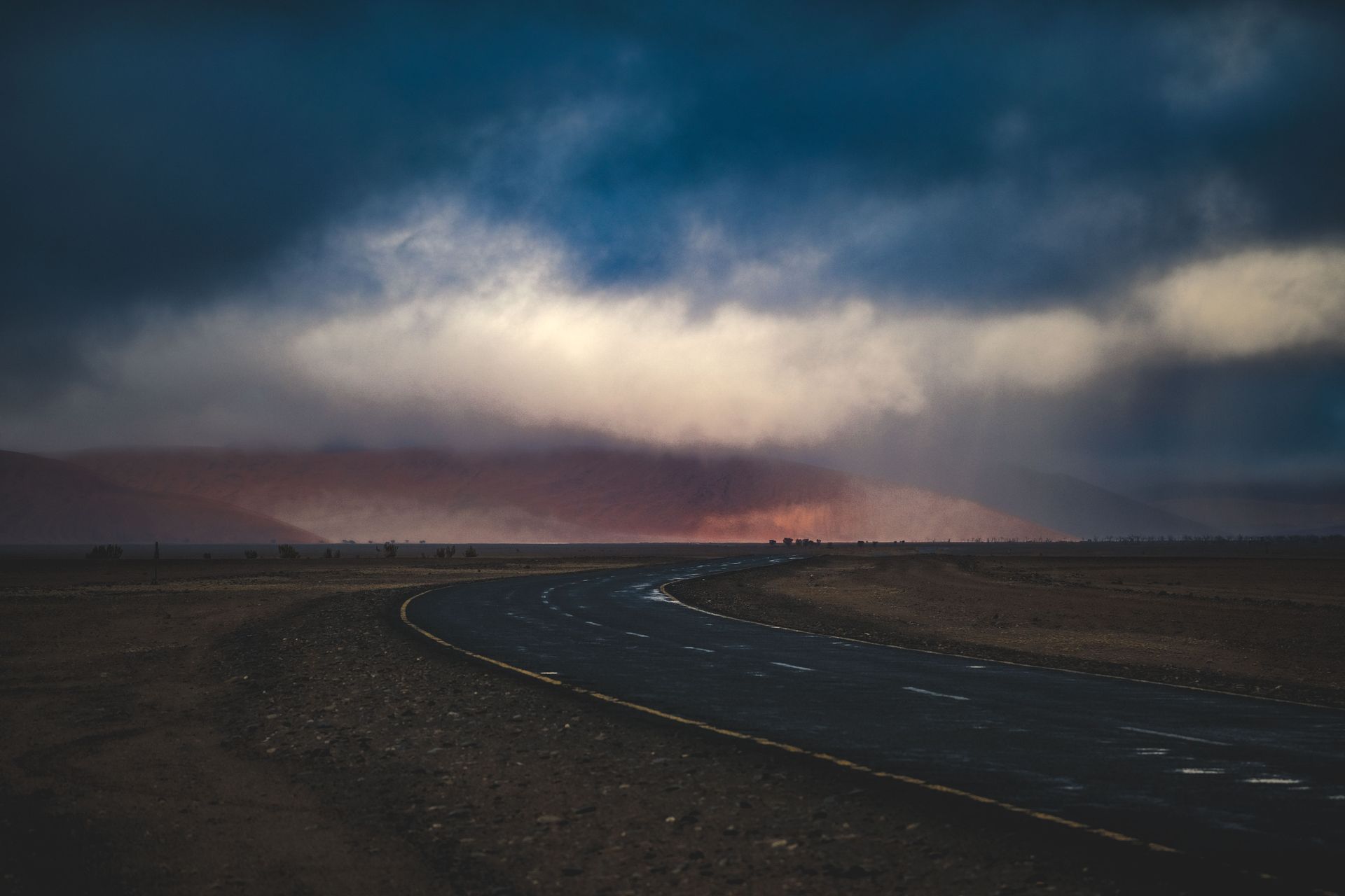 Storm clouds and blowing dust over an Arizona desert highway during monsoon season wind peril