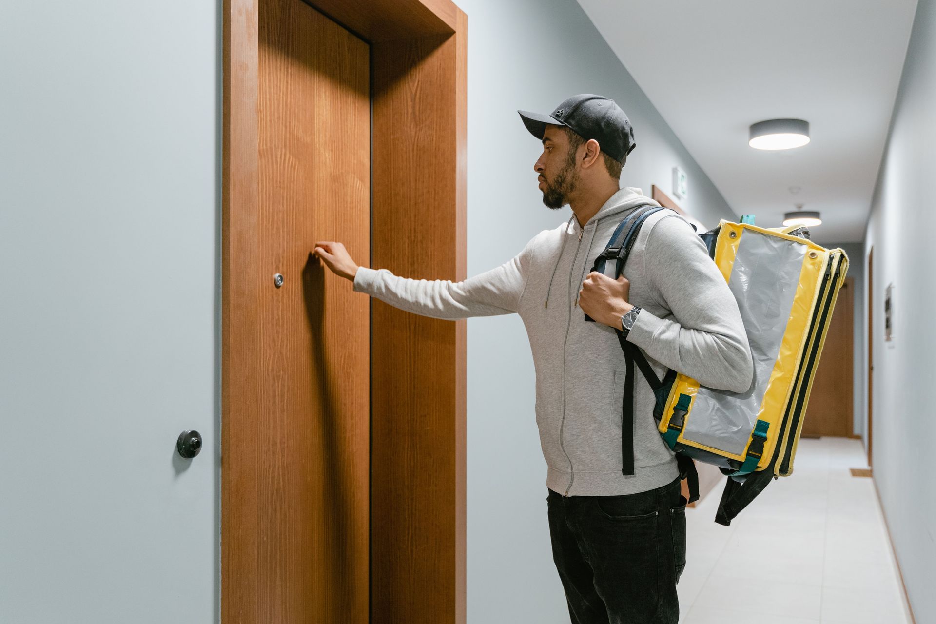 Uber Eats delivery driver carrying an insulated food bag to a customer's door in Arizona