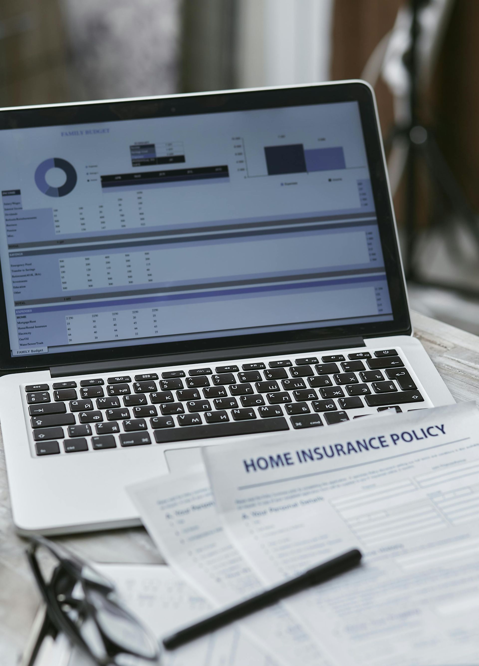 Laptop and home insurance policy document on a desk while buying home insurance in Arizona