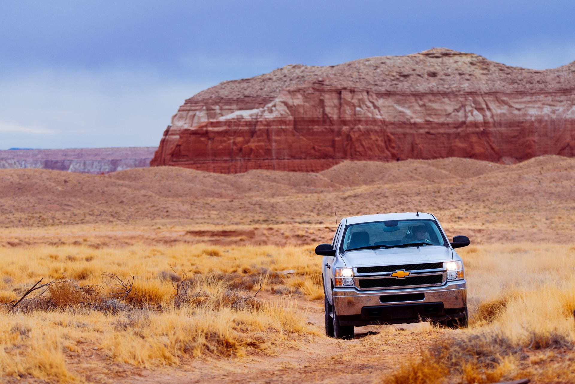 Pickup truck on a desert road representing rental car coverage in Arizona