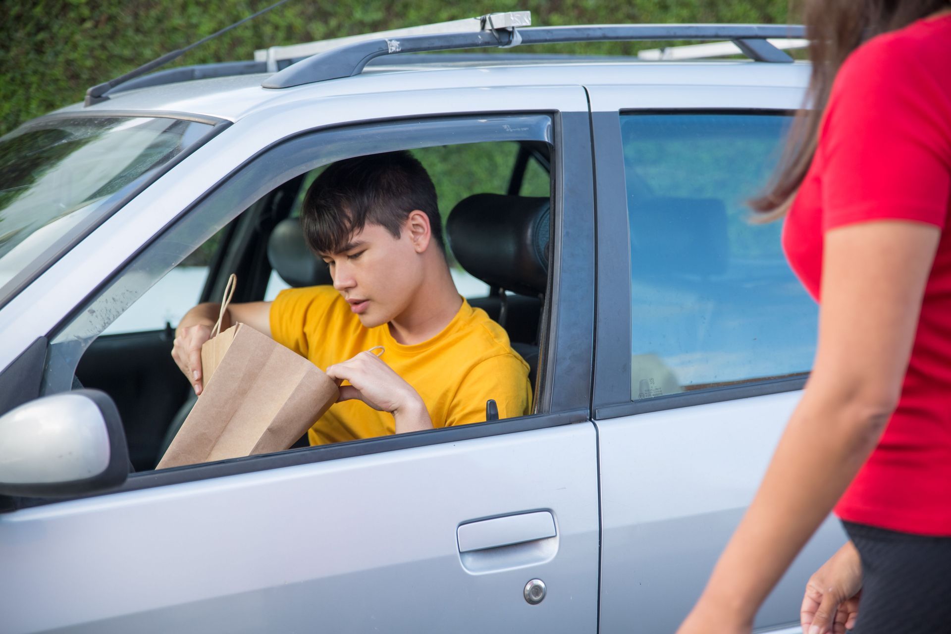 Uber Eats delivery driver in his car with a food order in Arizona, needing delivery insurance