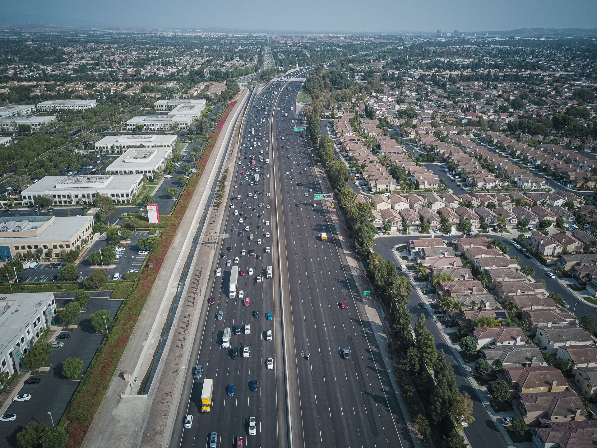 Aerial view of a busy Arizona freeway cutting through Surprise, AZ neighborhoods at rush hour