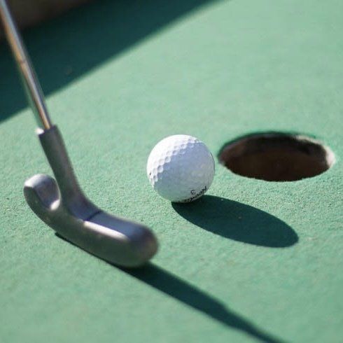 En golfboll sätts i ett hål med en putter