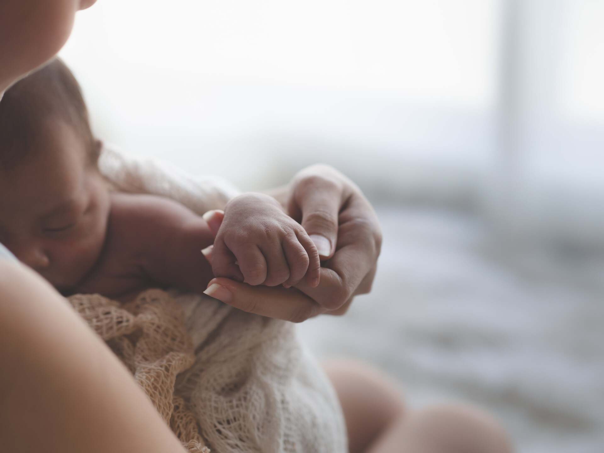 Uma mulher está segurando um bebê recém-nascido nos braços.