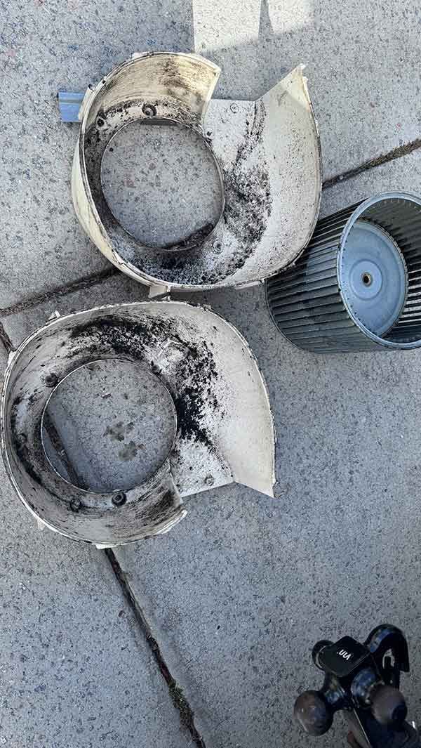 Two dirty white plastic filter housings and a cylindrical filter on a concrete floor
