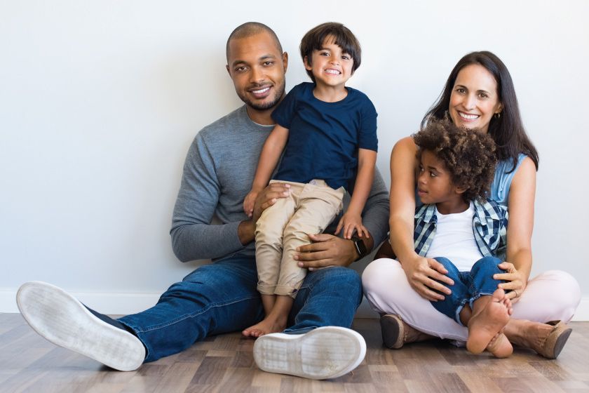 A family of four sitting on the floor