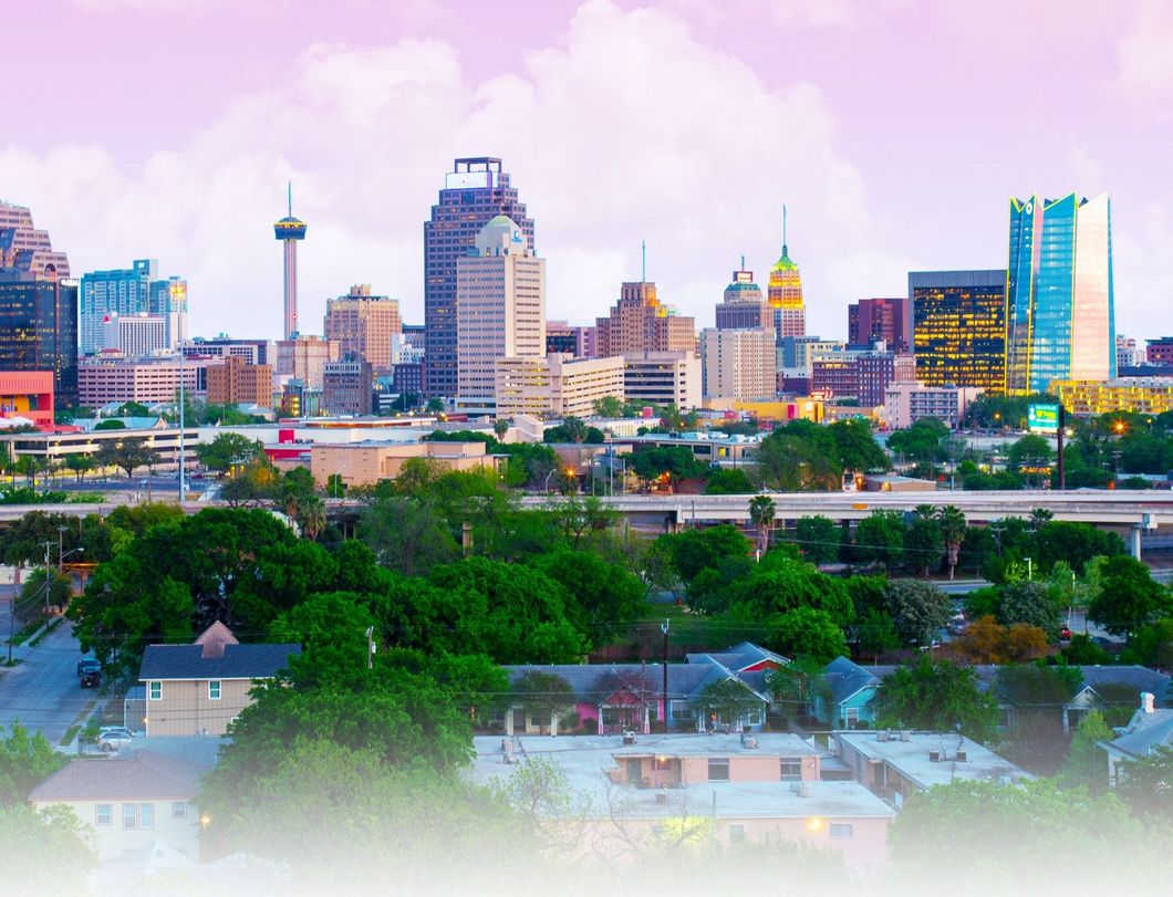 An aerial view of a city skyline with trees in the foreground