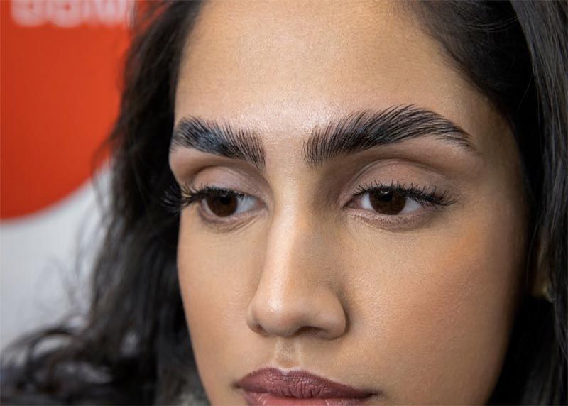 A close up of a woman 's face with a very thick eyebrow.