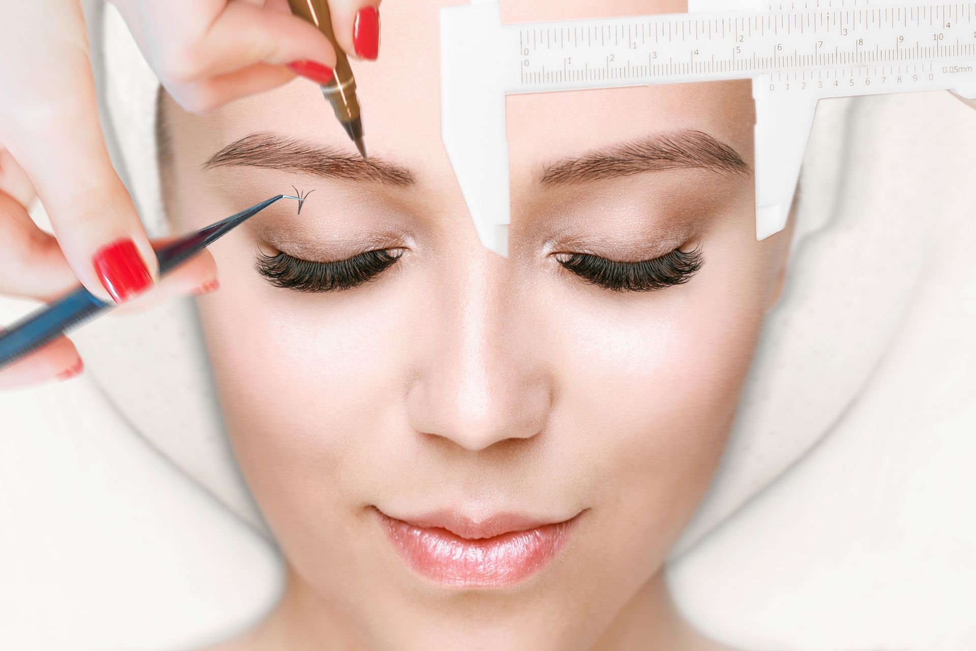 A woman is getting her eyebrows measured with a ruler.