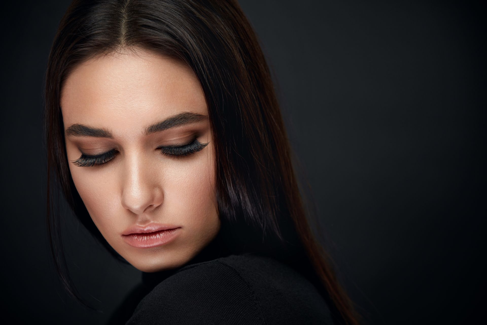 A close up of a woman 's face with her eyes closed.