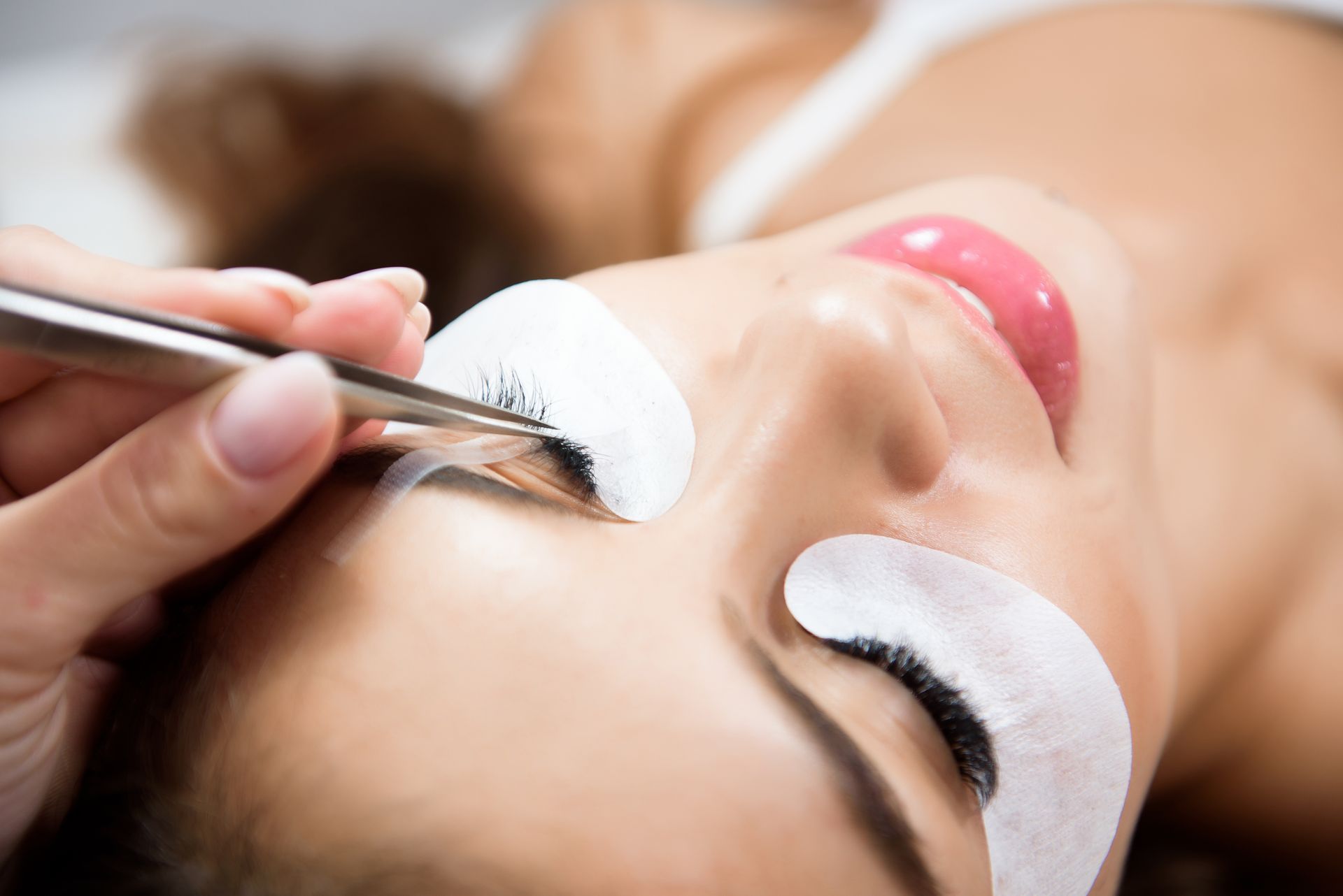 A woman is getting her eyelashes done at a beauty salon.