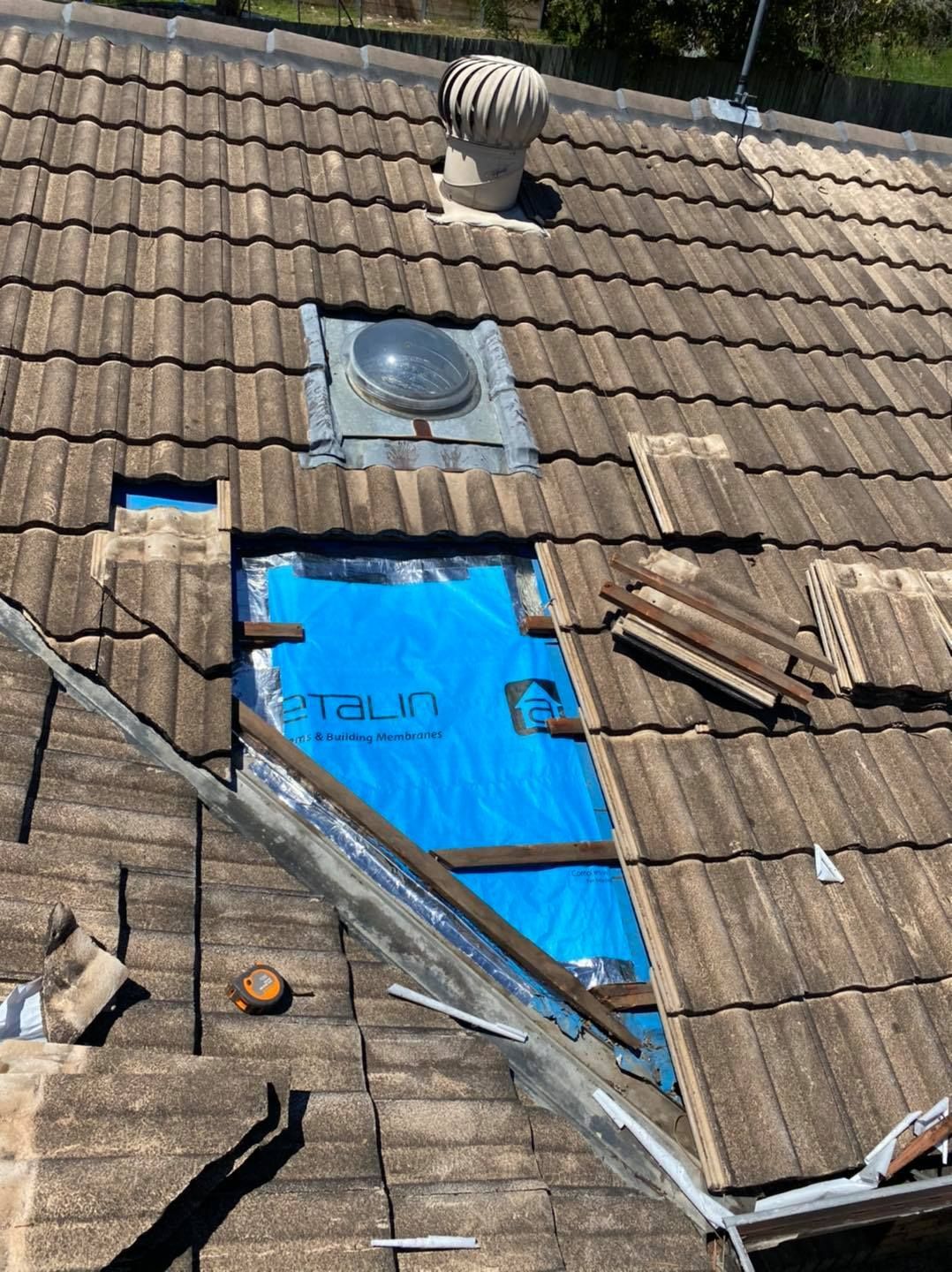 Rooftop With Missing Tiles, Blue Tarp Covering an Opening, and a Skylight — SEQ Roofing & Painting in Coomera, QLD