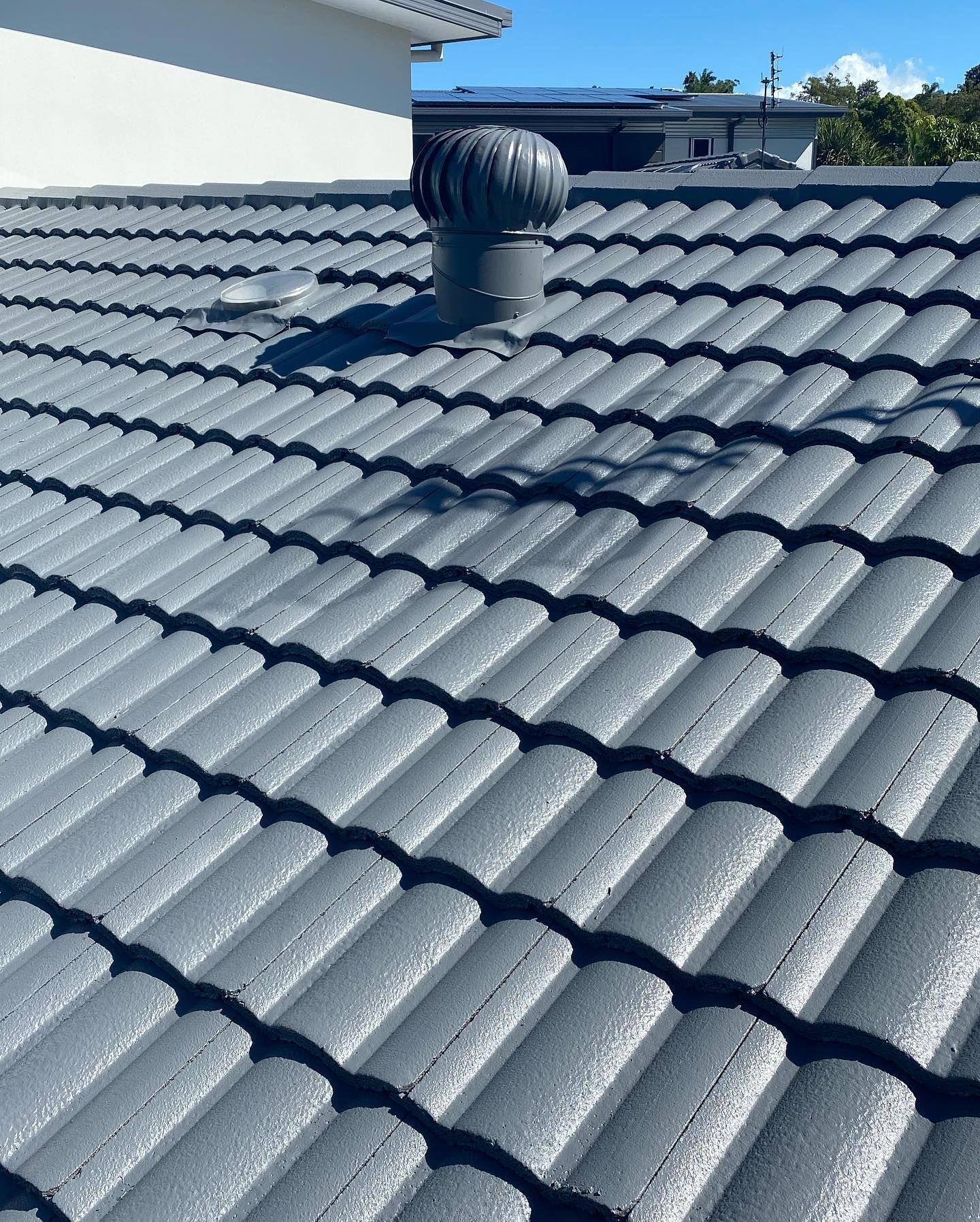 Gray Tiled Roof With a Ventilation Turbine on a Sunny Day — SEQ Roofing & Painting in Mermaid Waters, QLD