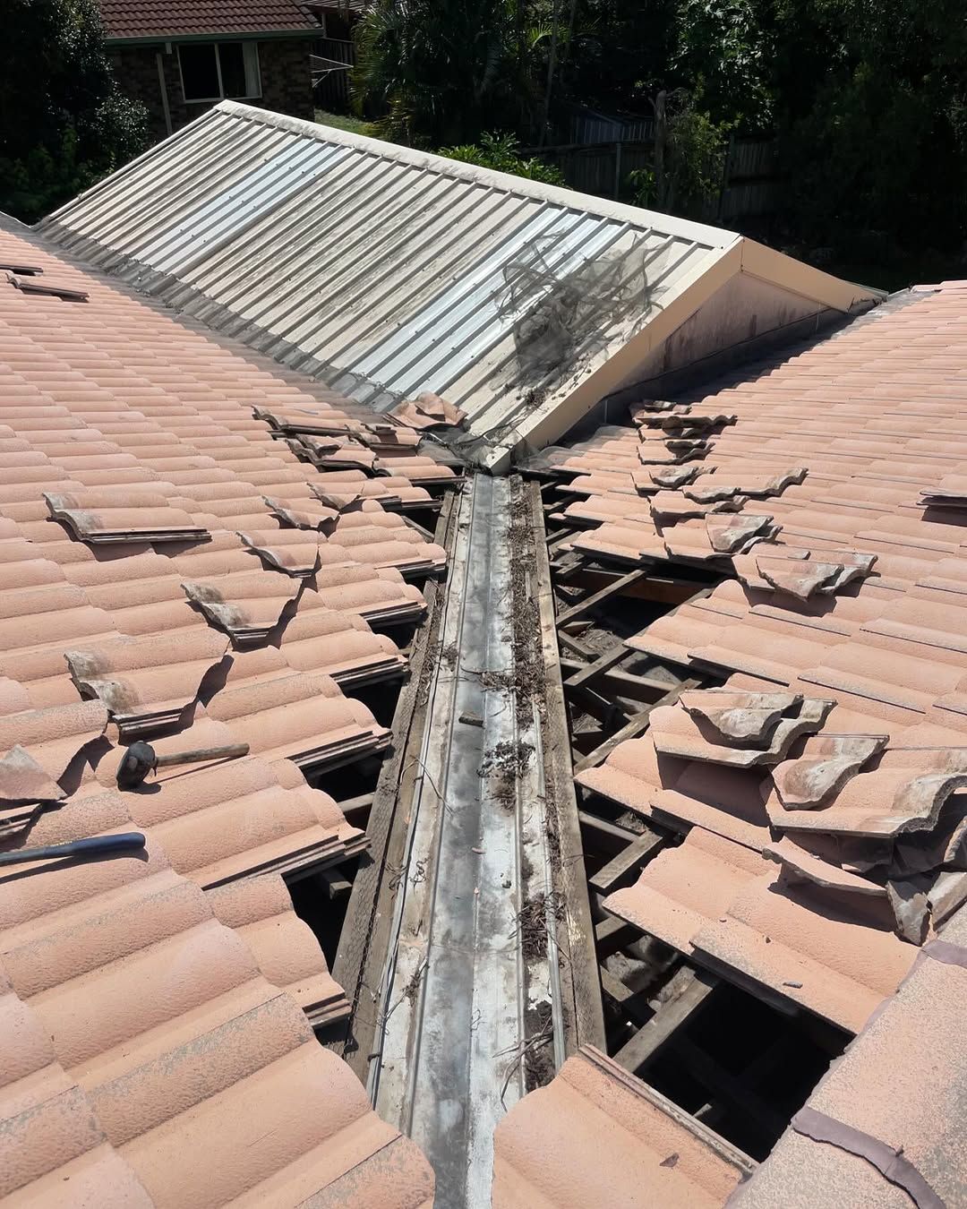Damaged Terracotta Tile Roof With a Deteriorated Metal Valley; Sunlight — SEQ Roofing & Painting in Mudgeeraba, QLD