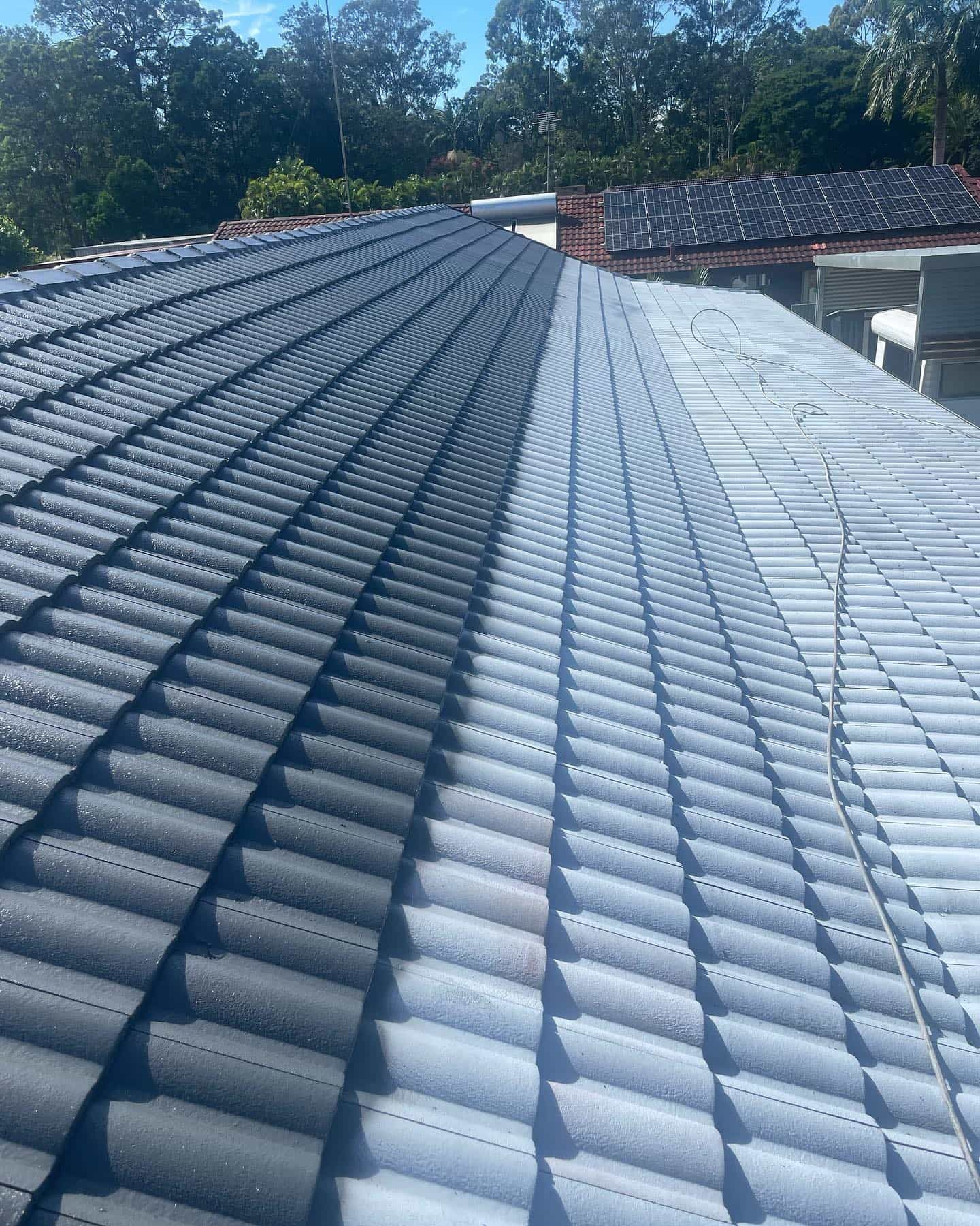 Half of a Tiled Roof is Dark Gray and Cleaned Lighter Gray — SEQ Roofing & Painting in Nerang, QLD