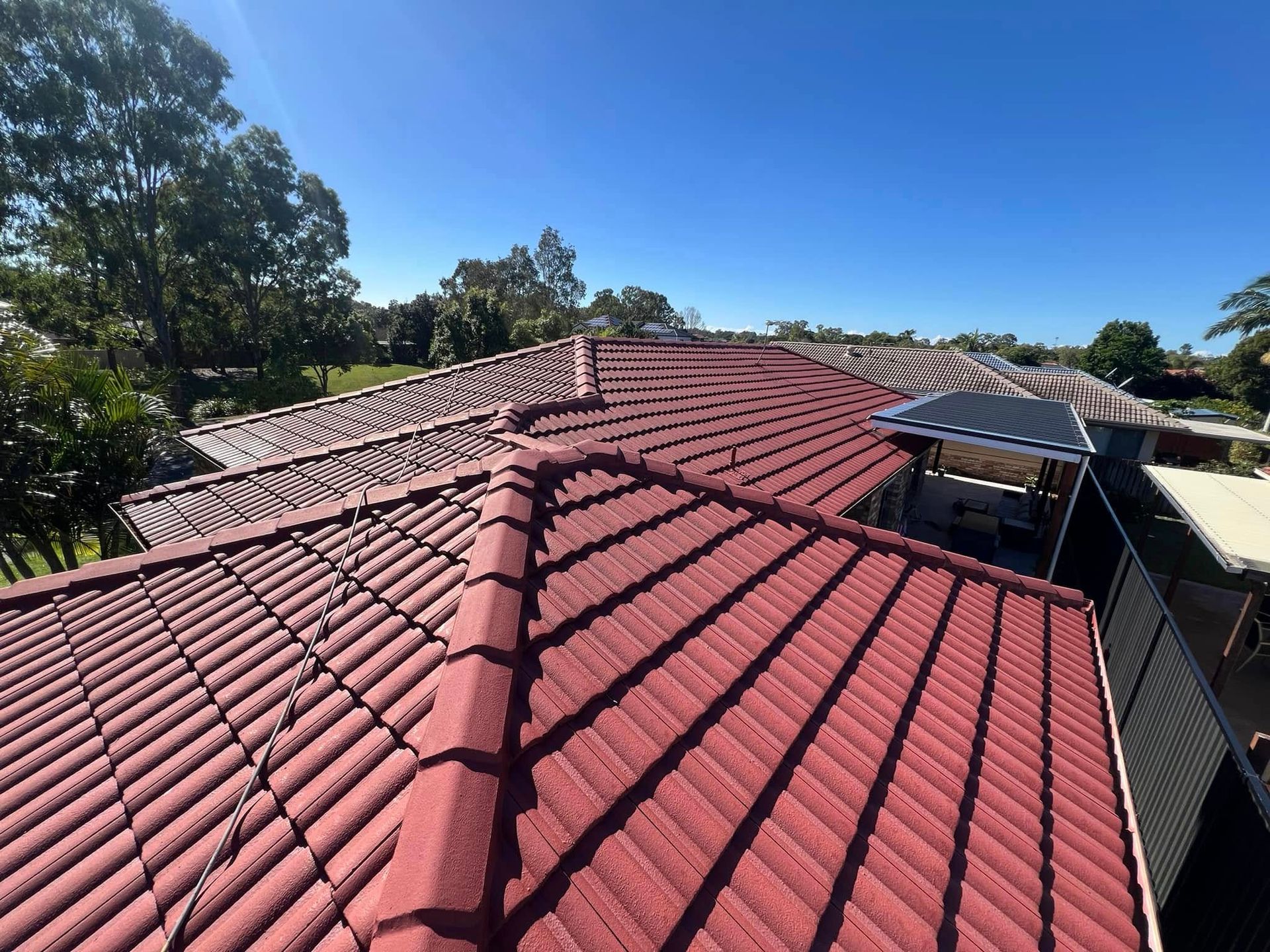 Red Tile Roof on A Sunny Day with Clear Blue Sky — SEQ Roofing & Painting in Nerang, QLD