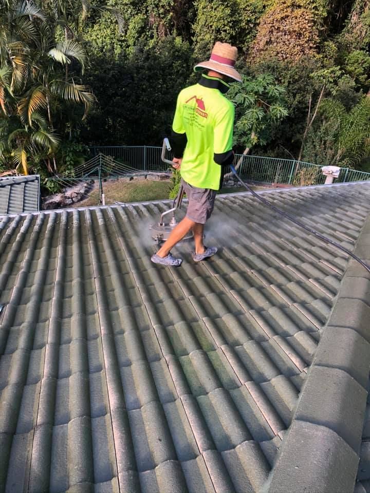 Person Power Washing a Tiled Roof, the Person Wears a Straw Hat and a Neon Shirt — SEQ Roofing & Painting in Currumbin, QLD