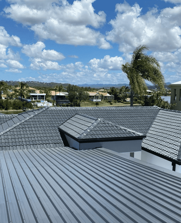 Gray Metal Roof with A Scenic View of Homes Under a Cloudy Blue Sky  — SEQ Roofing & Painting in Nerang, QLD