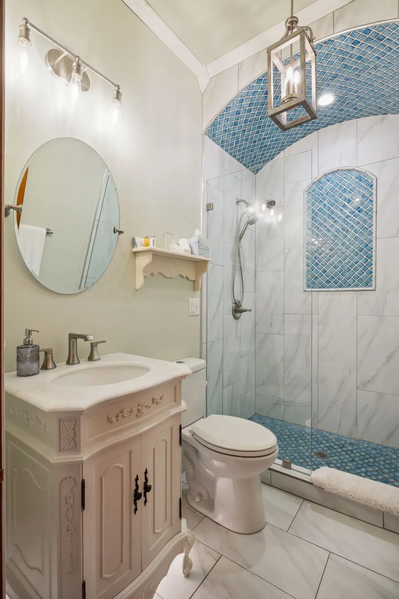 A bathroom with a toilet , sink , mirror and shower.