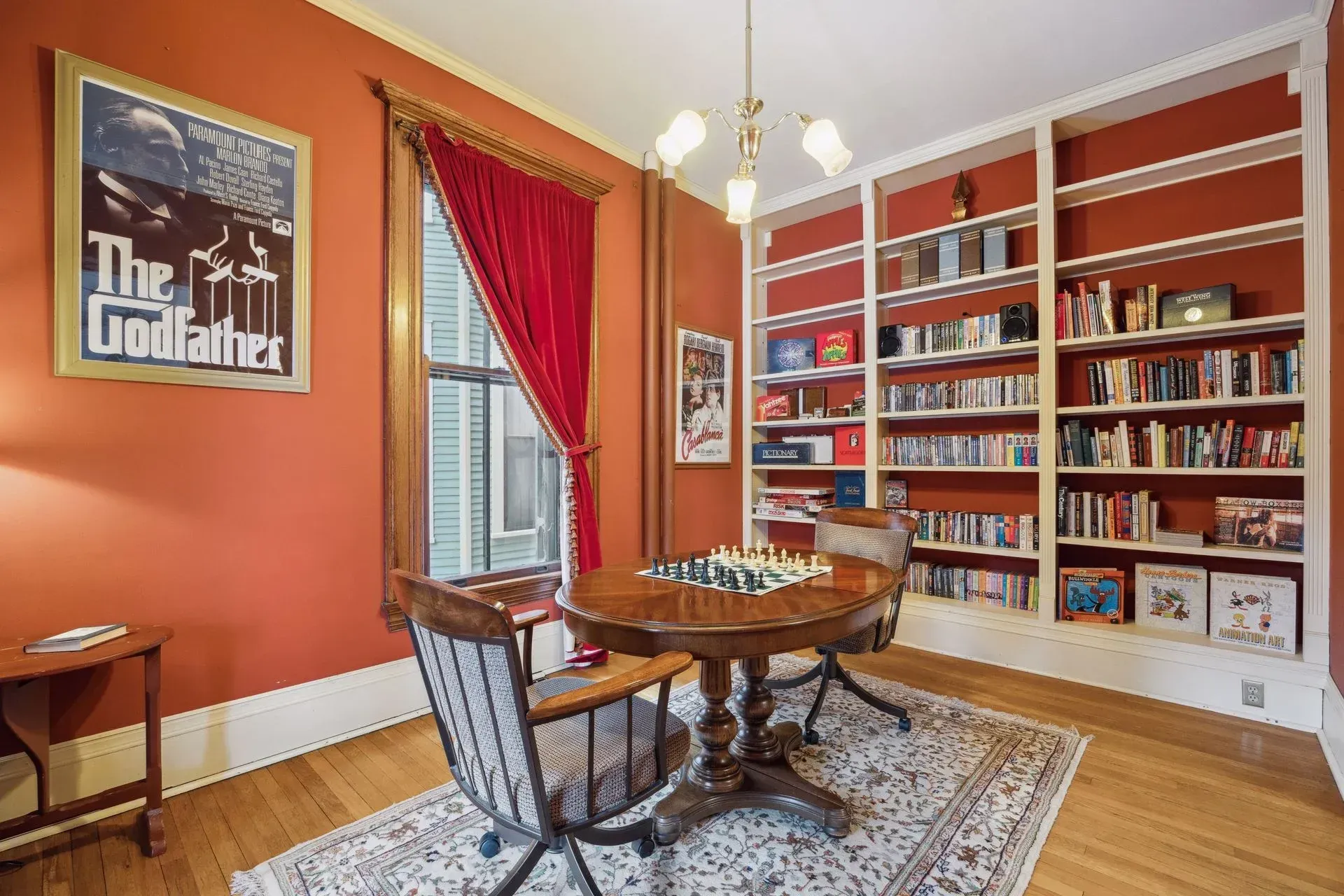 A dining room with a table and chairs and a poster of the godfather on the wall.