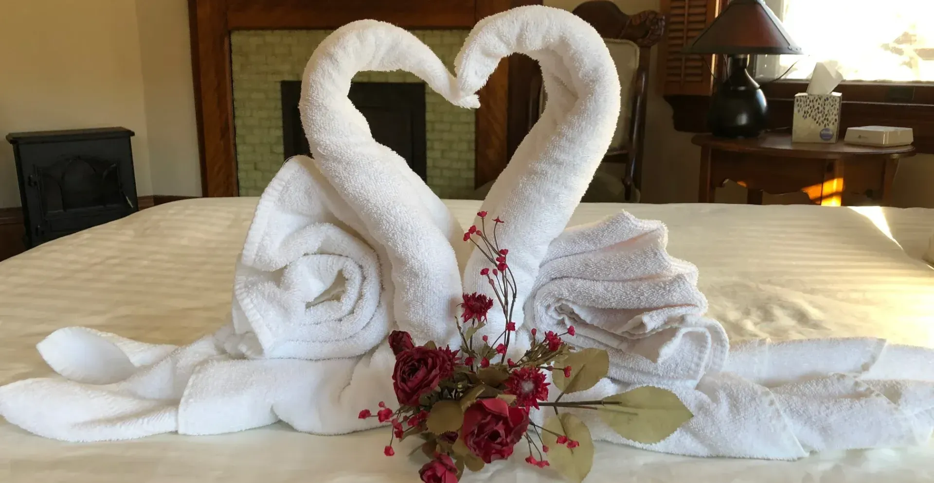 Two swans made out of towels on a bed