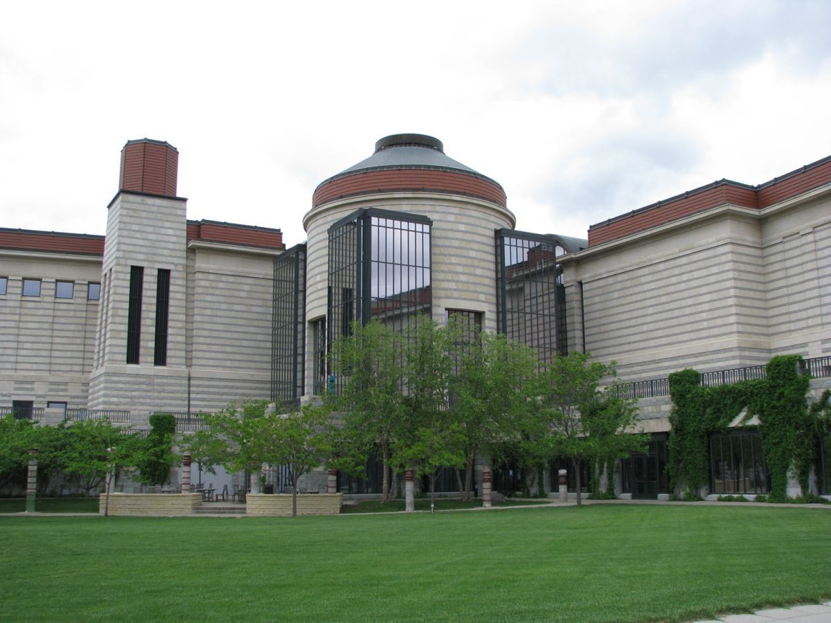 A large building with a lot of windows and trees in front of it