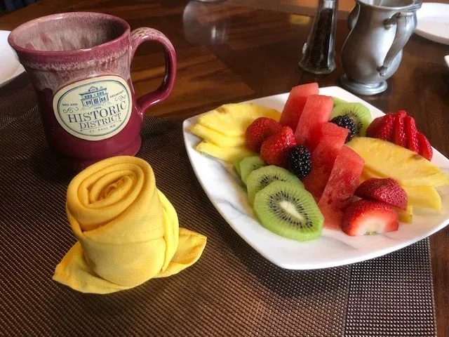 A plate of fruit next to a mug that says history on it