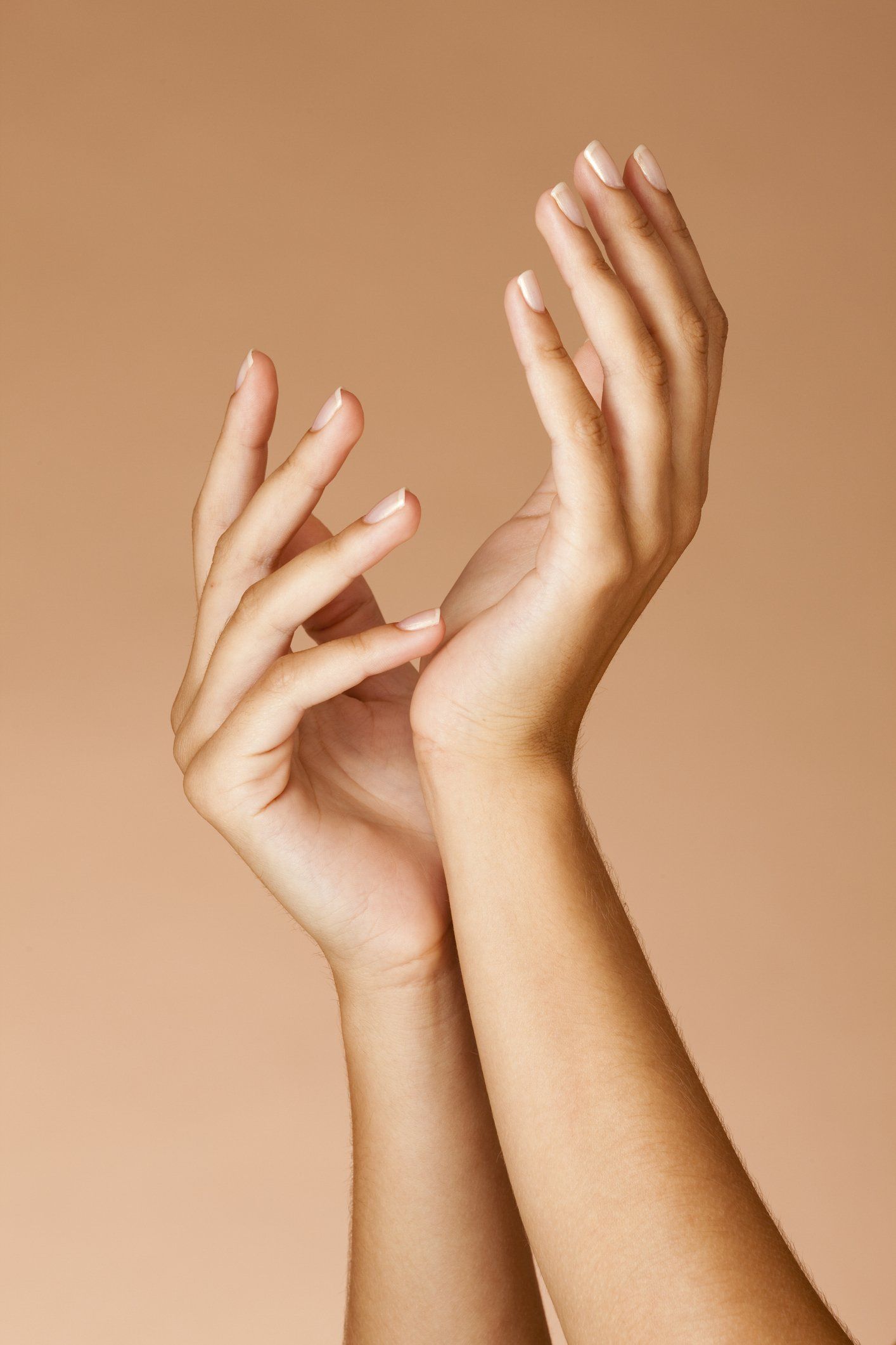mani di donna con sfondo marrone chiaro