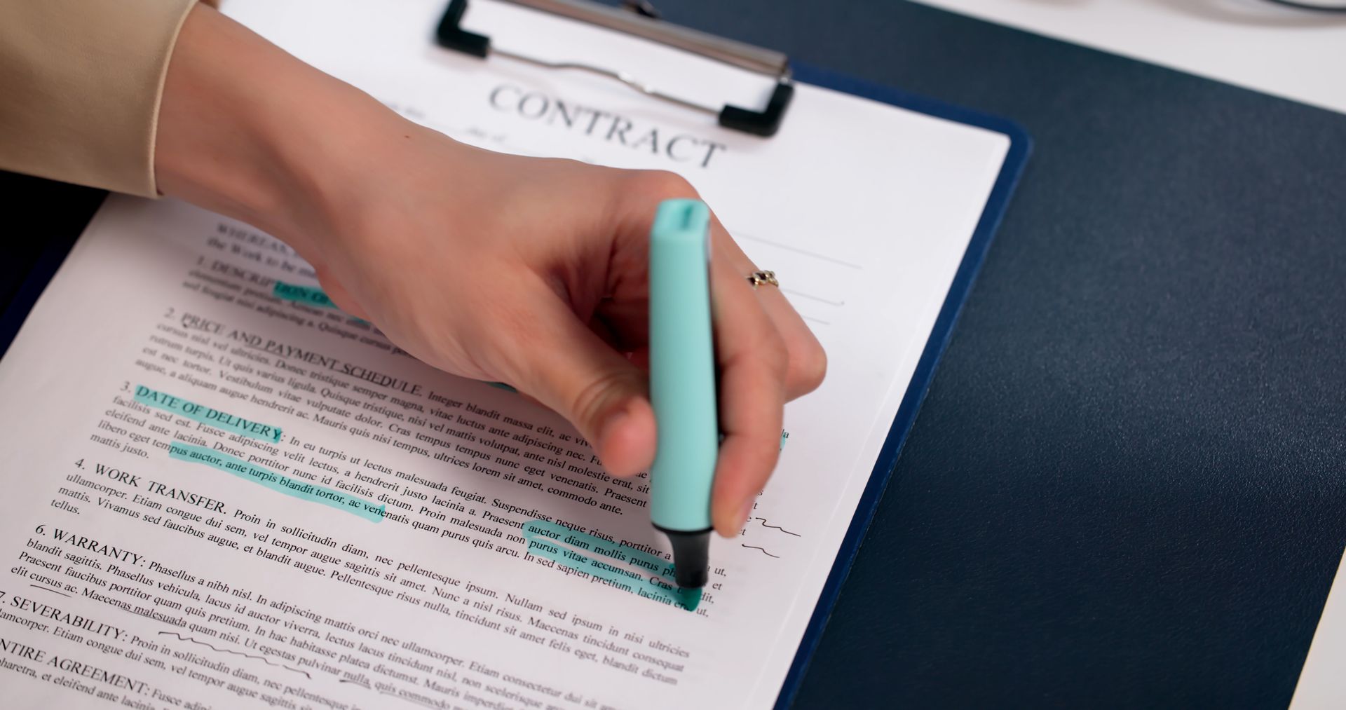 A person is highlighting a contract.