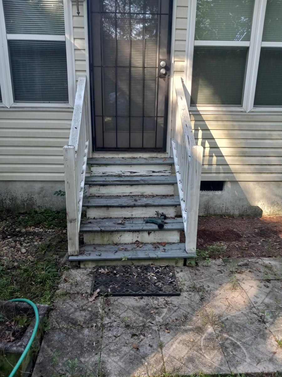 A house with stairs leading up to the front door.