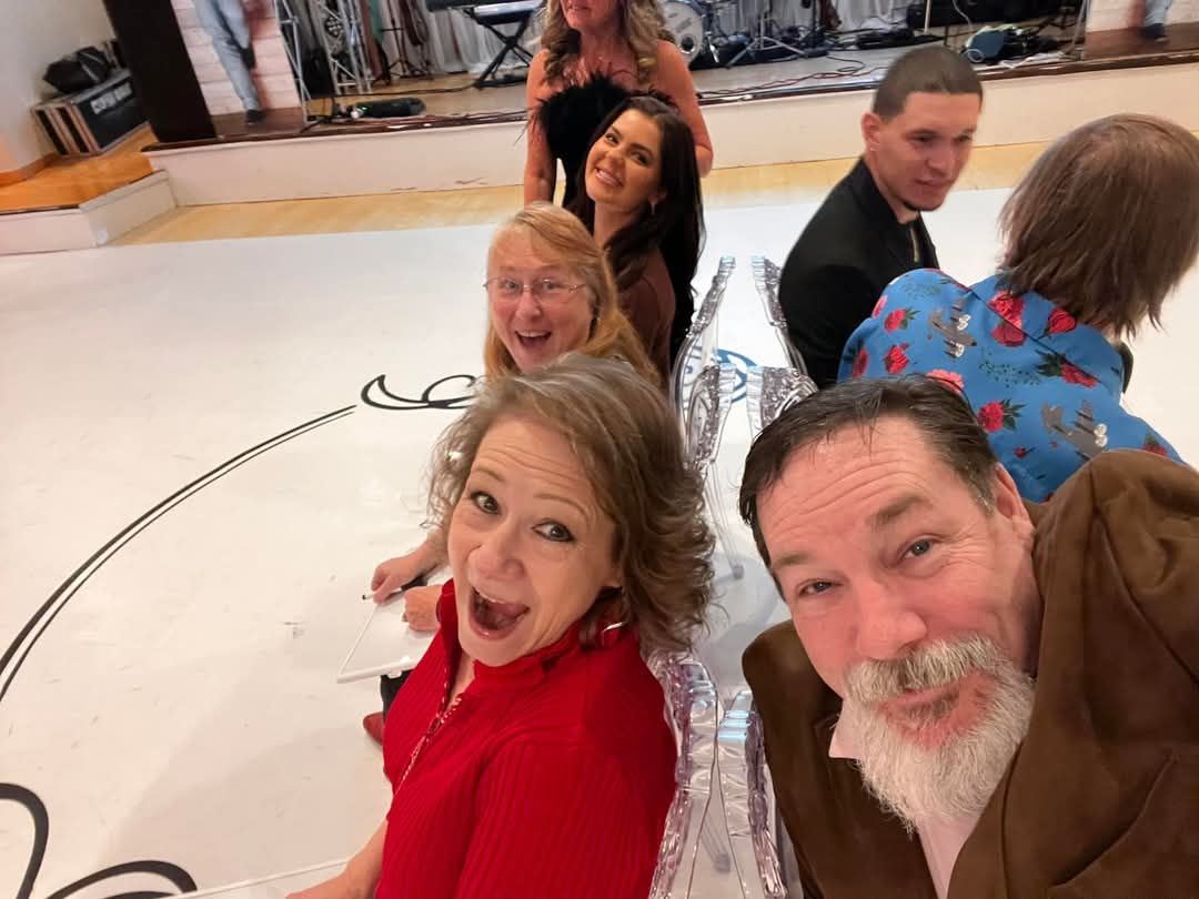 A group of people are posing for a picture on a dance floor.