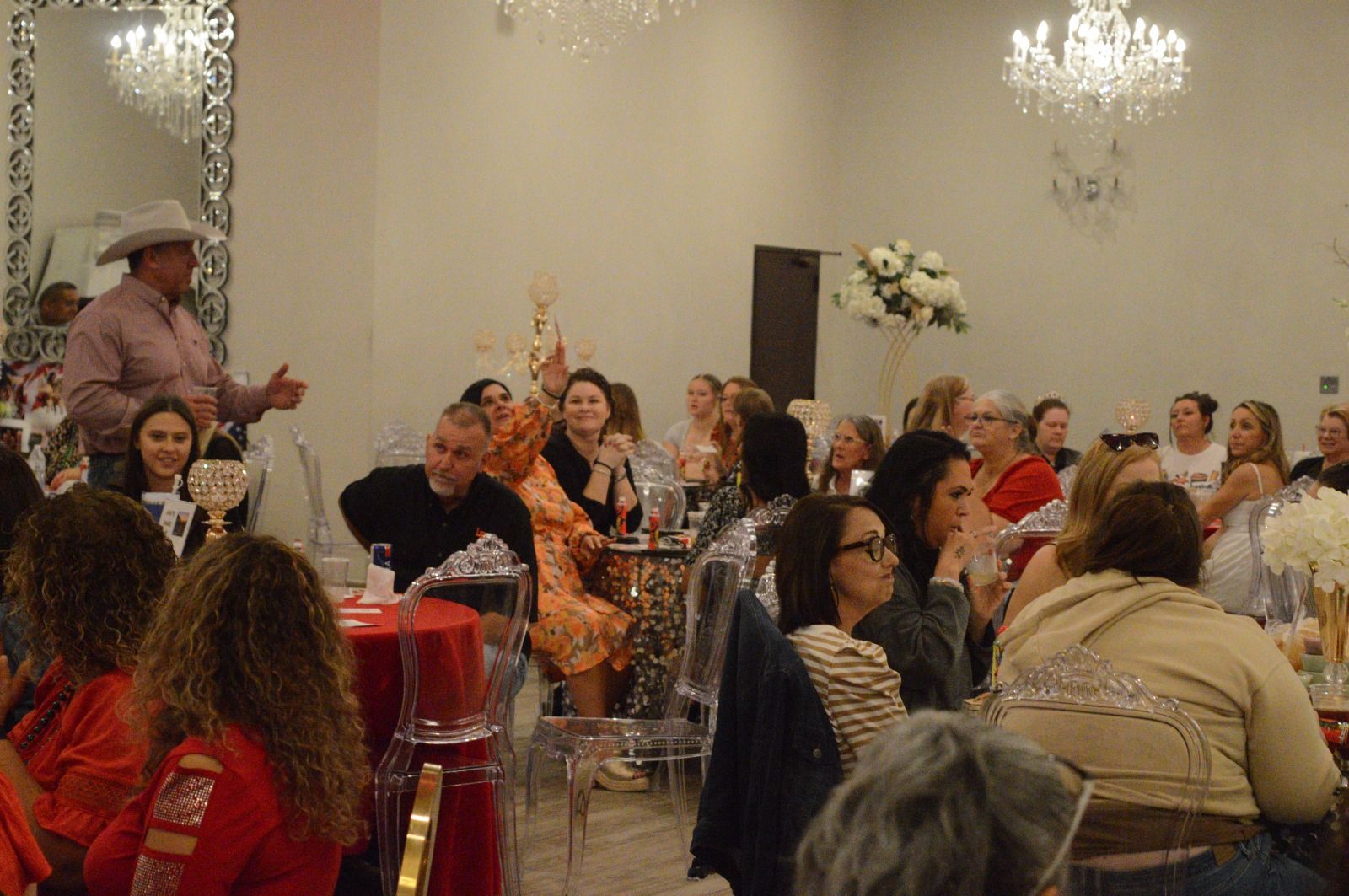 A large group of people are sitting at tables in a room.