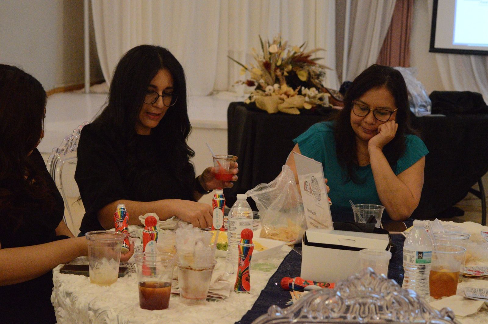 Three women are sitting at a table with drinks.