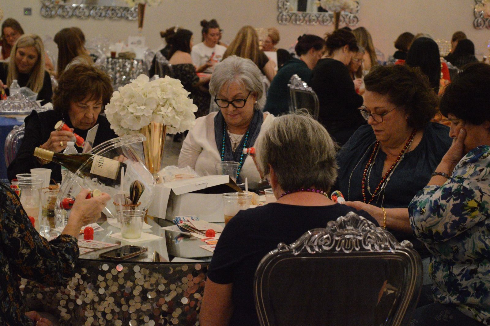 A group of women are sitting at a table at a party.
