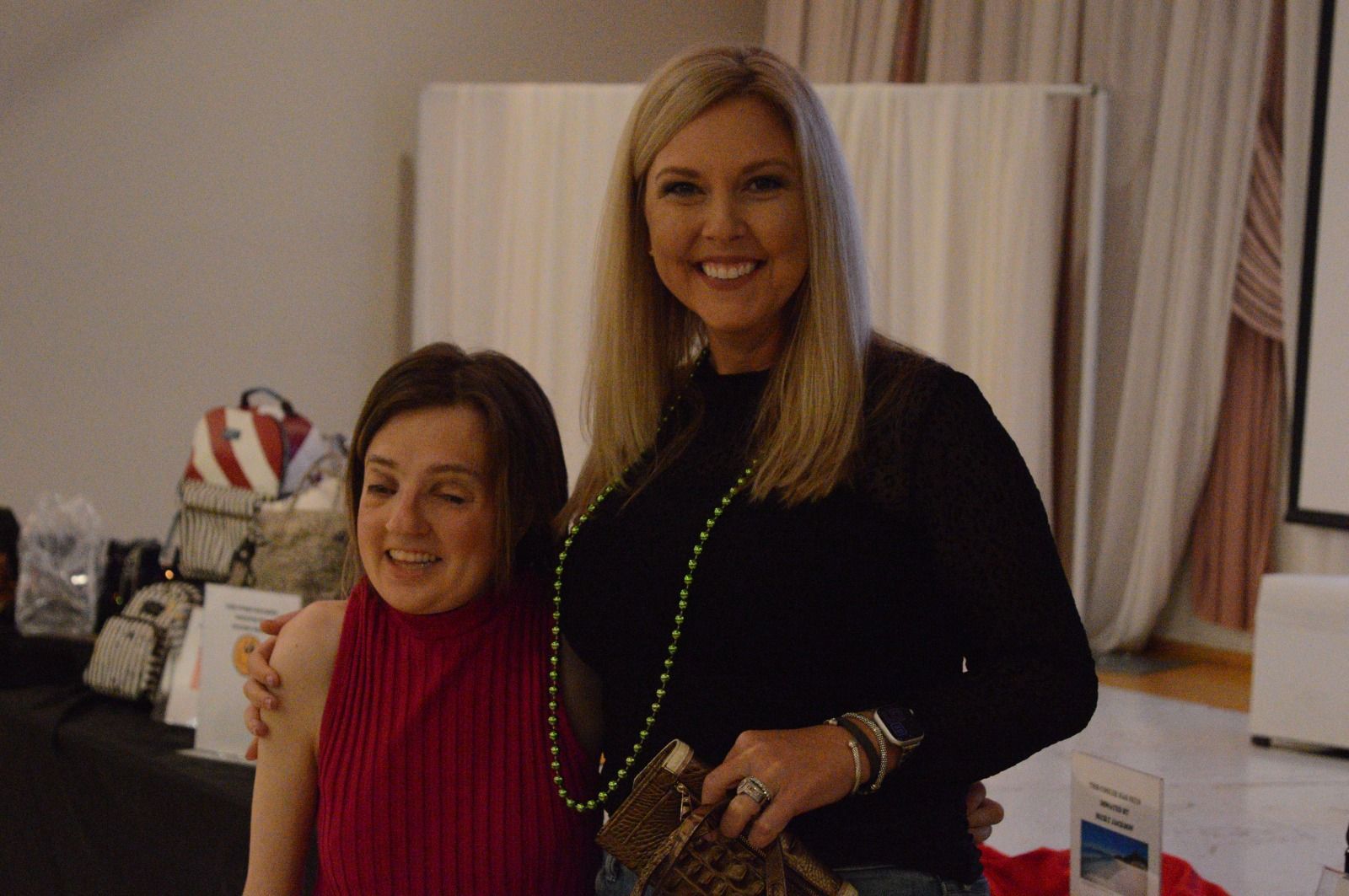 Two women are posing for a picture together in a room.